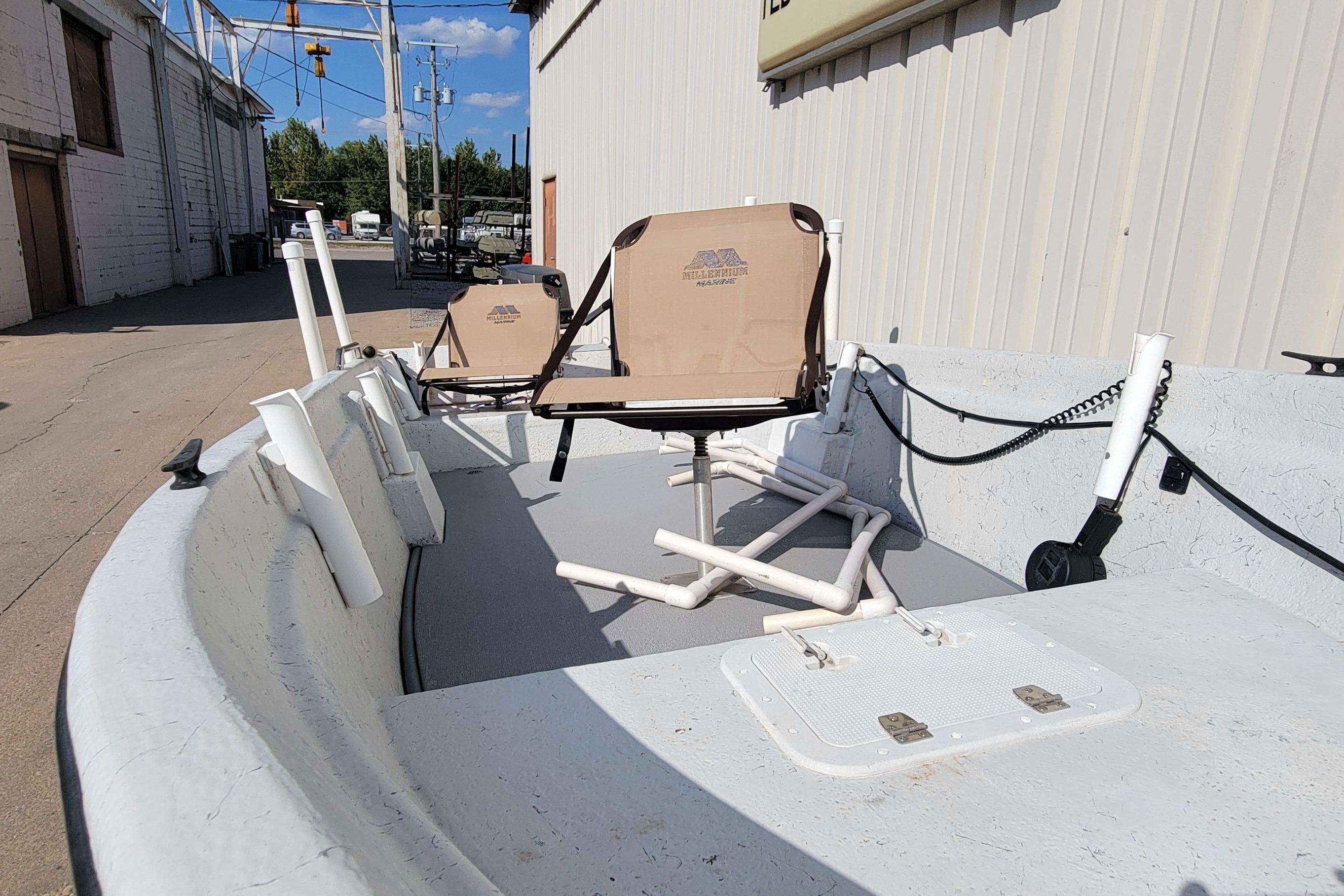 1996 DILKES STUMP JUMPER boat with beige seats, docked near industrial buildings.
