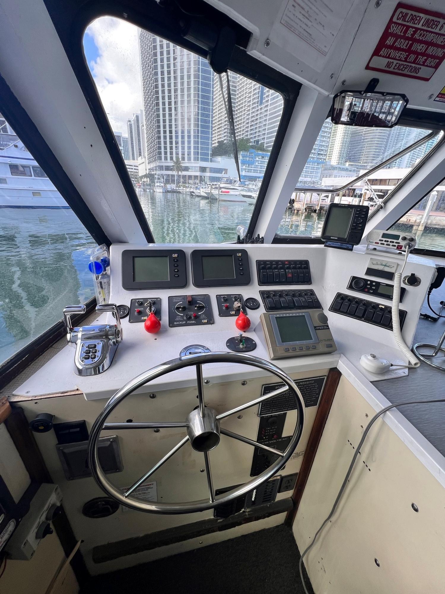 Custom-58 Tour Vessel 1990-CANYON ODYSSEY FL-US-Cockpit of a 1990 Custom 58 Tour Vessel with modern navigation equipment.-8685116 | Thumbnail