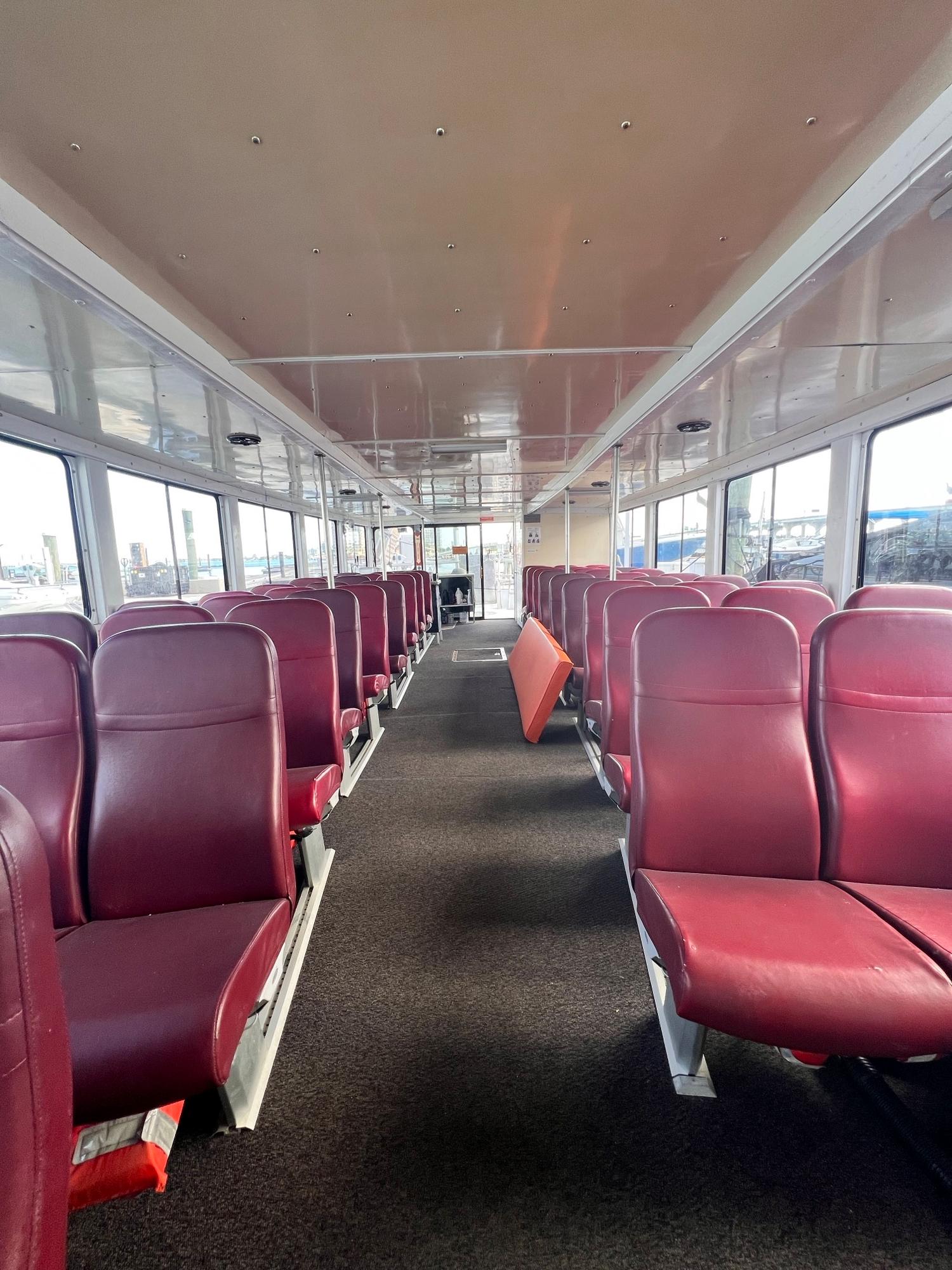 Custom-58 Tour Vessel 1990-CANYON ODYSSEY FL-US-Interior of a 1990 Custom 58 Tour Vessel with red seats and large windows.-8685116 | Thumbnail