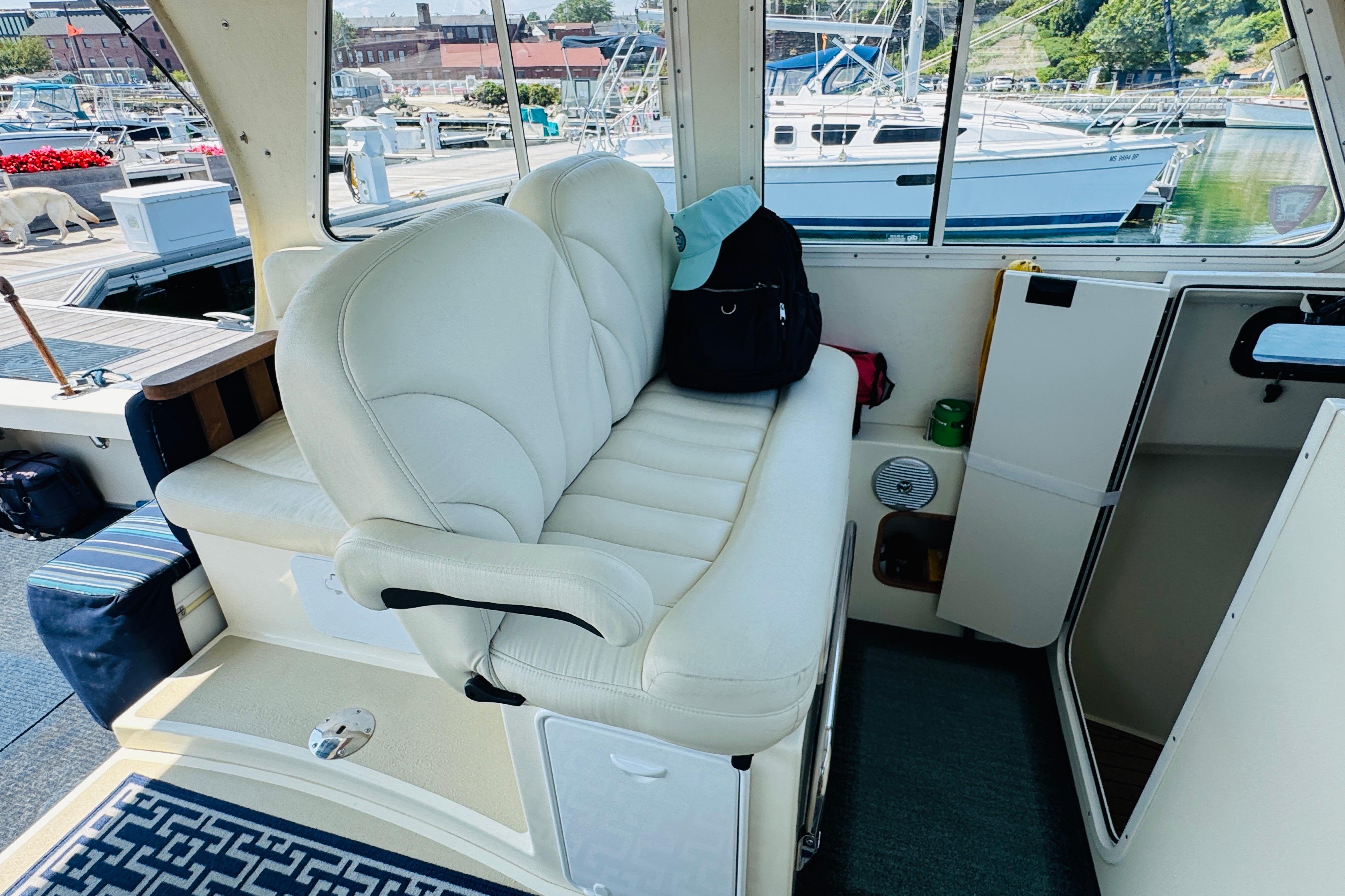 Interior of 2015 Eastern 270 Islander boat with white seating and marina view.
