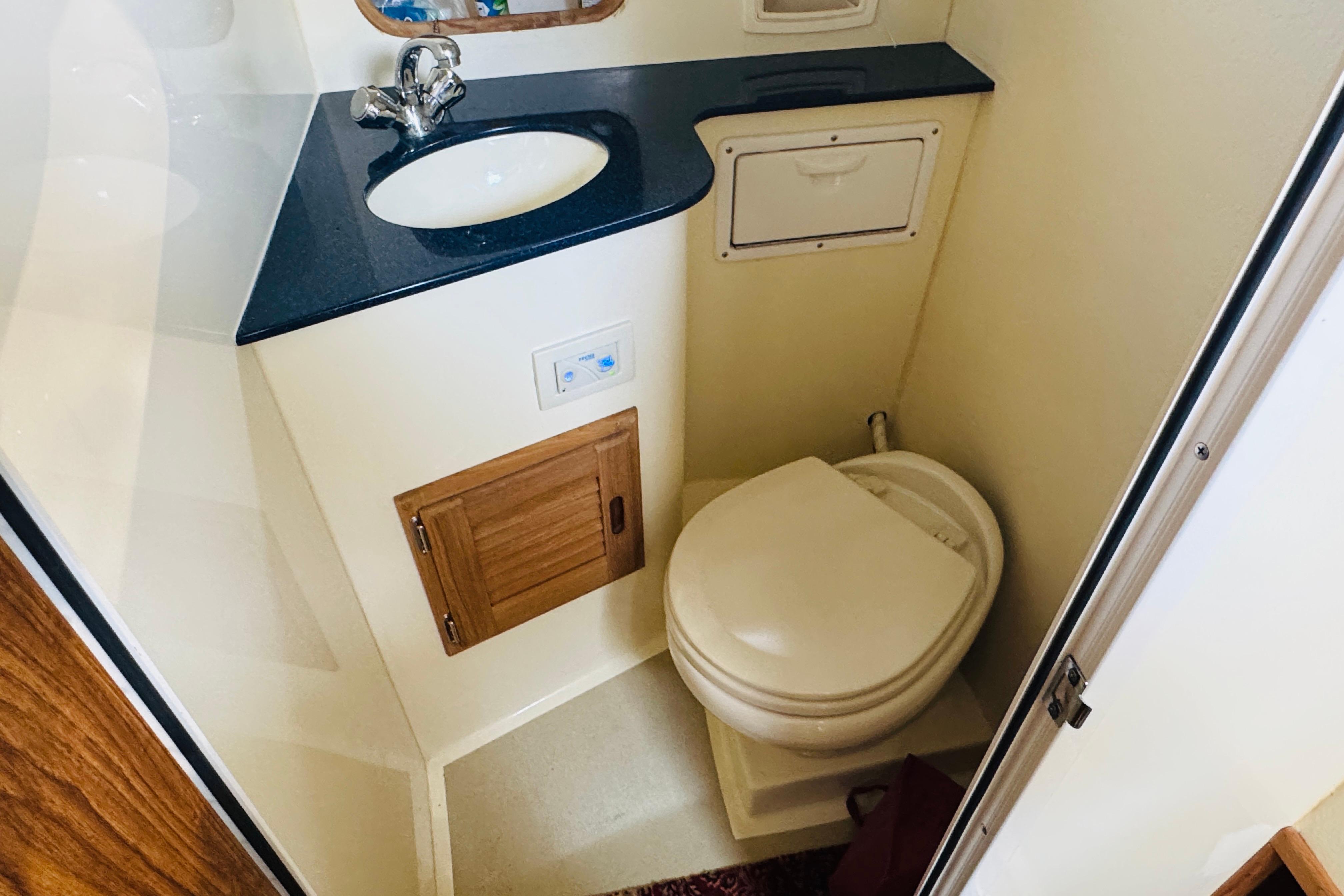 Compact bathroom in 2015 Eastern 270 Islander boat with sink and toilet.
