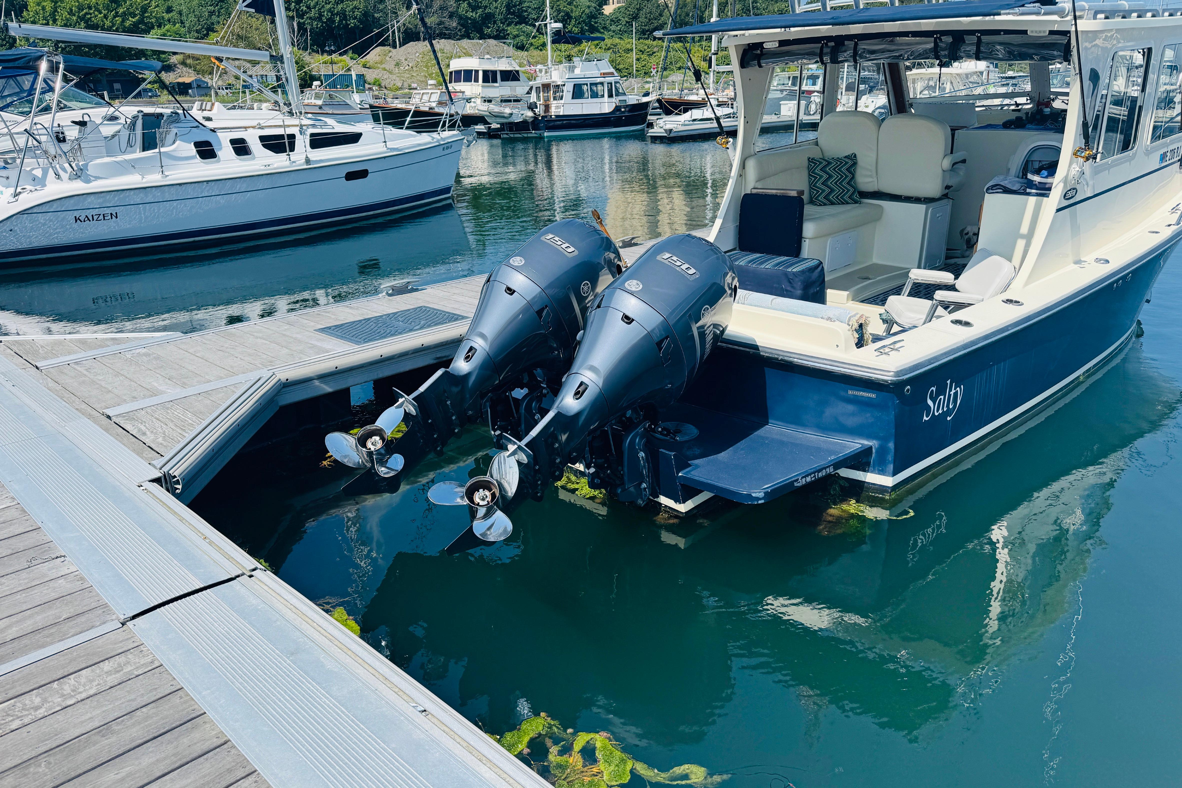 2015 Eastern 270 Islander boat docked with dual outboard motors in a marina.
