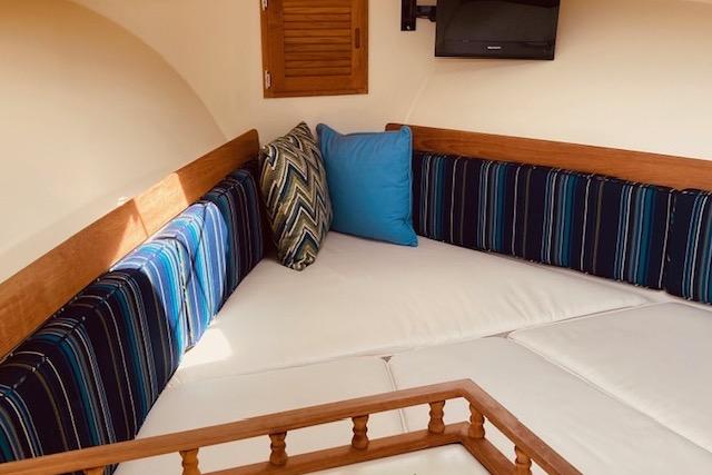 Cozy interior of 2015 Eastern 270 Islander boat with striped cushions and pillows.