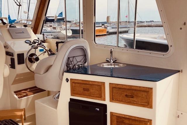 Interior of 2015 Eastern 270 Islander boat with helm, sink, and storage.