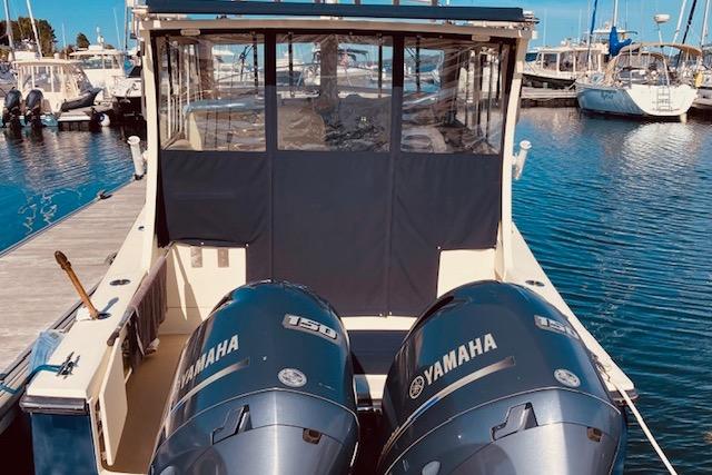 2015 Eastern 270 Islander boat with twin Yamaha 150 engines docked at marina.
