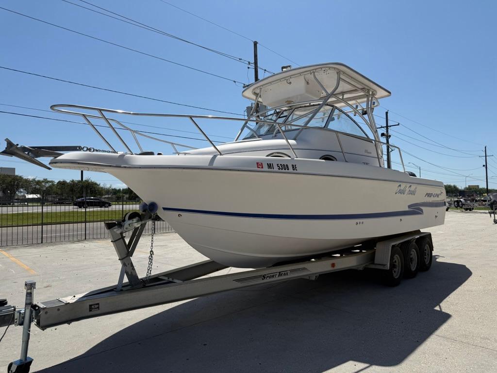 2000 Pro-Line 27 Walk boat on trailer, parked outdoors under clear sky.