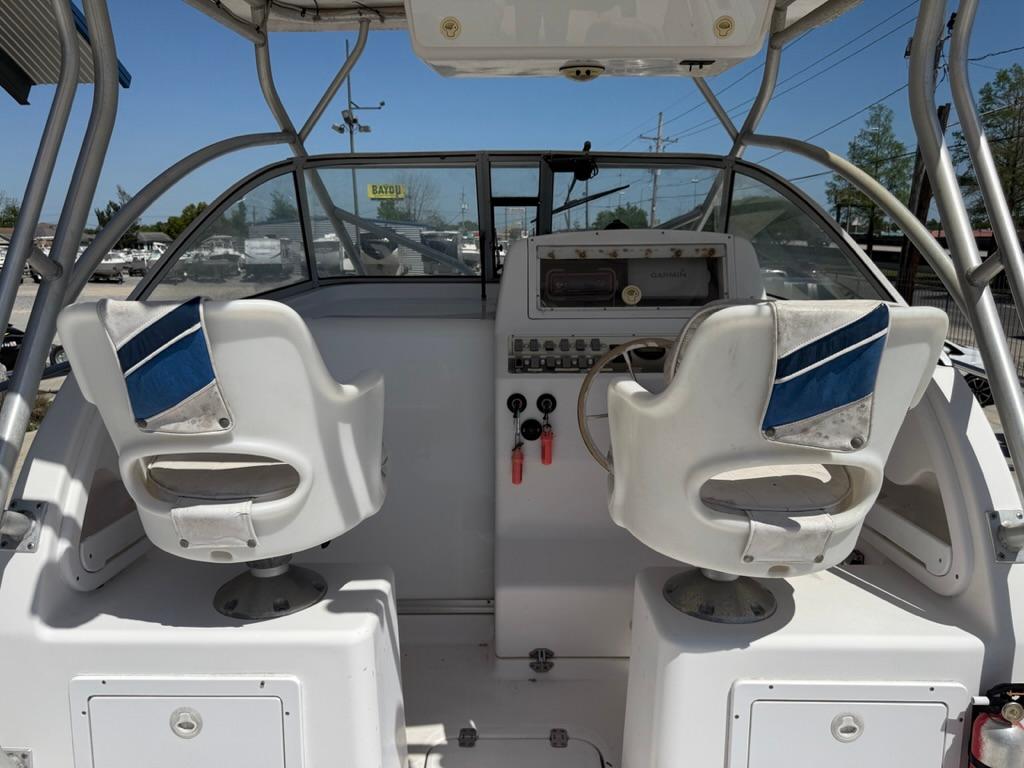 2000 Pro-Line 27 Walk boat cockpit with dual white seats and control panel.
