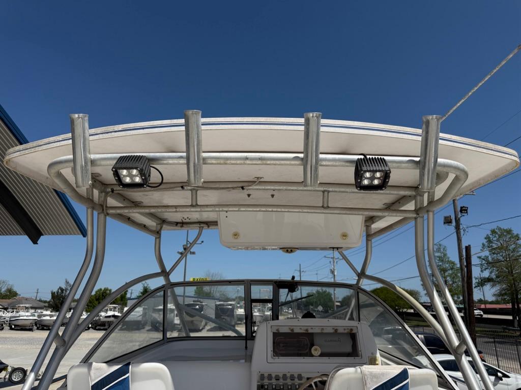 2000 Pro-Line 27 Walk boat with T-top and electronics, docked under clear blue sky.