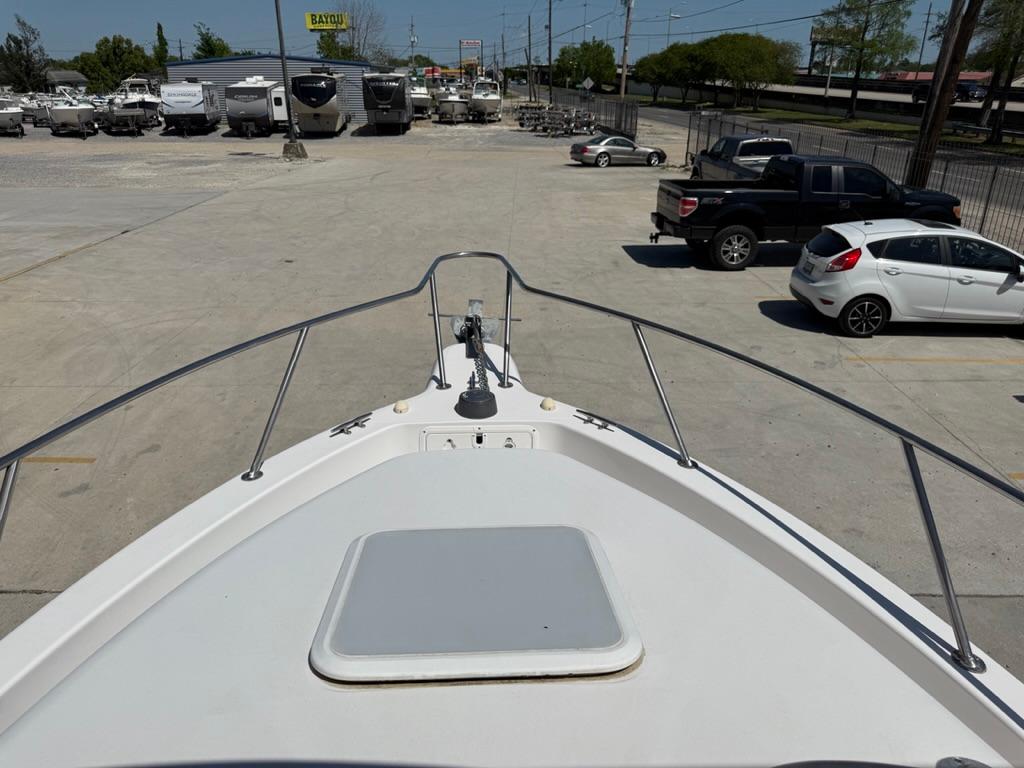 Bow view of 2000 Pro-Line 27 Walk boat in a parking lot.
