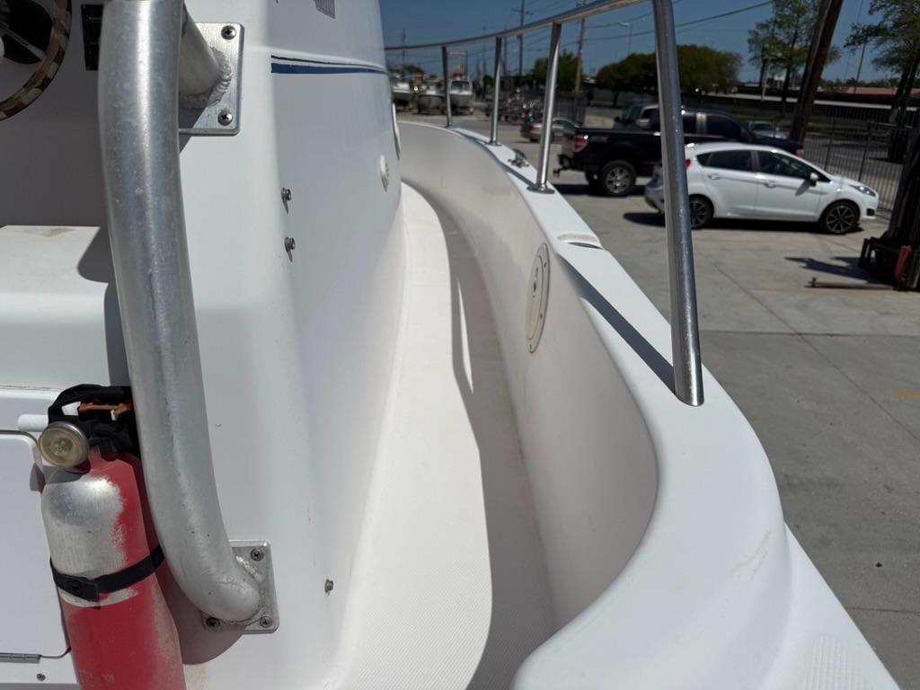 2000 Pro-Line 27 Walk boat deck with railing and fire extinguisher, parked in a lot.