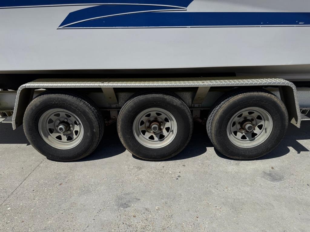 Triple-axle trailer for 2000 Pro-Line 27 Walk boat, side view.