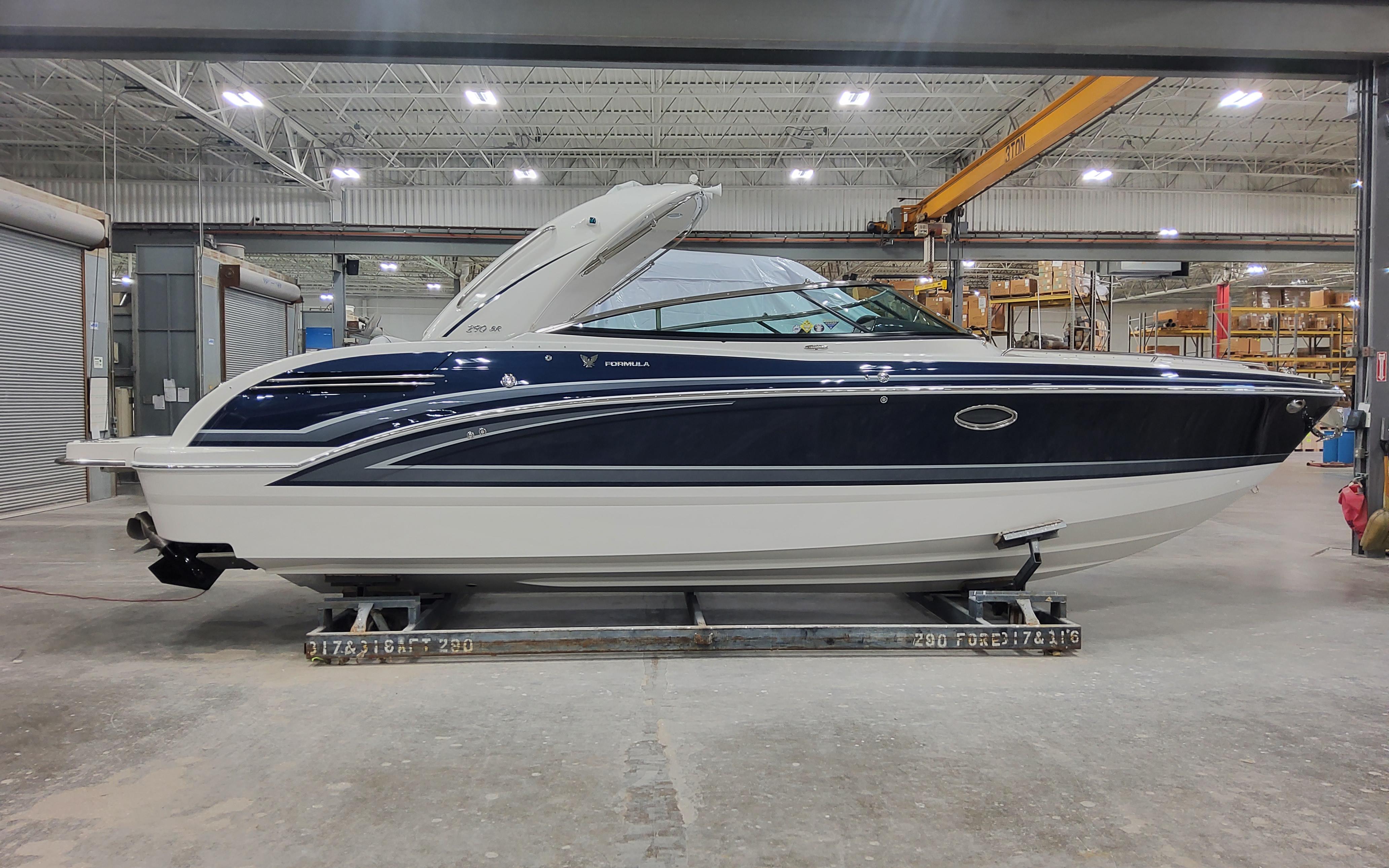 2026 Formula 290 Bowrider boat in a warehouse setting, side view.