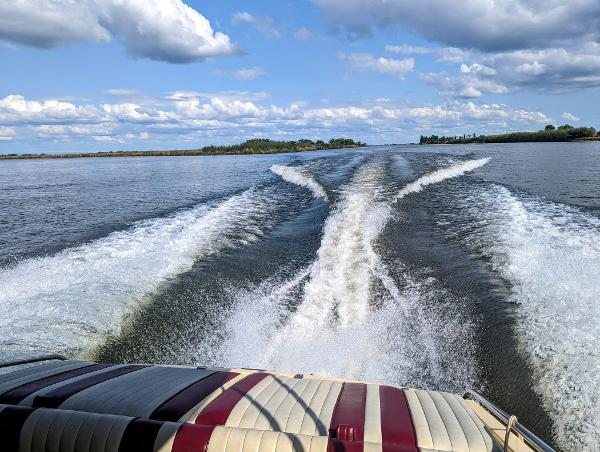 1980 Tahiti Ocean Racer speeding on a lake, leaving a wake under a partly cloudy sky.