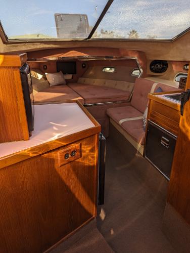 Interior of 1980 Tahiti Ocean Racer yacht with cozy seating and wooden cabinetry.