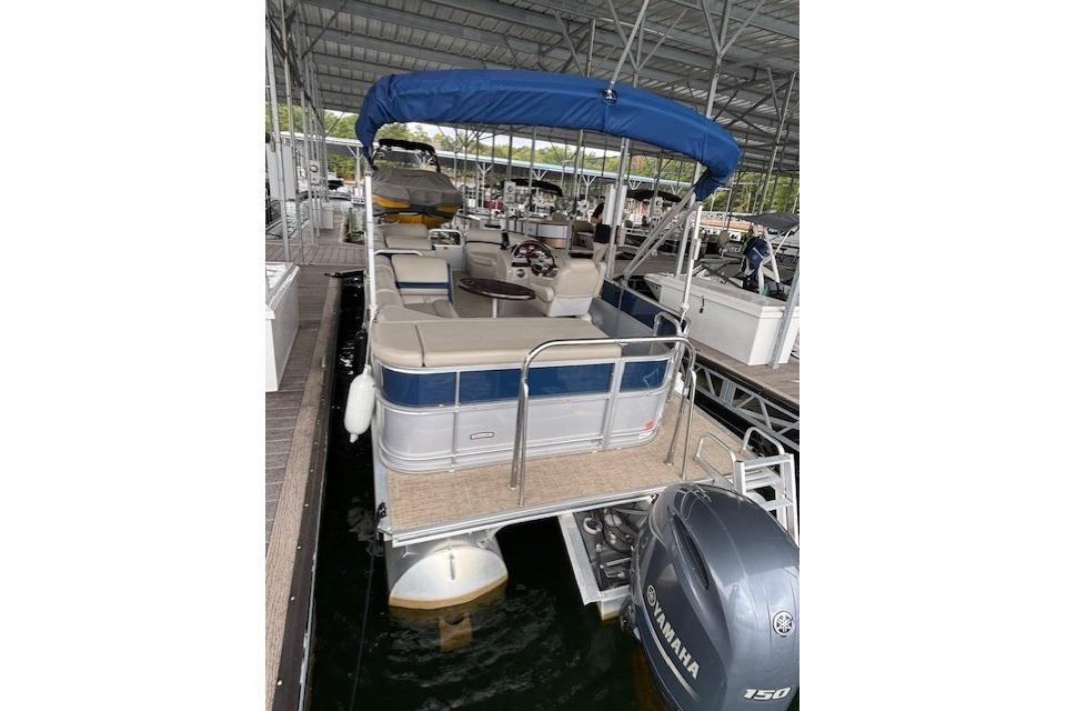 2017 South Bay 222 RS pontoon boat with blue canopy docked in marina.