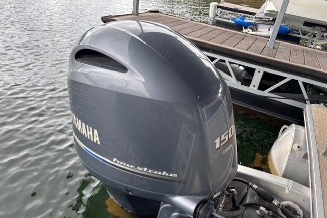 Outboard motor on 2017 South Bay 222 RS pontoon boat docked on water.