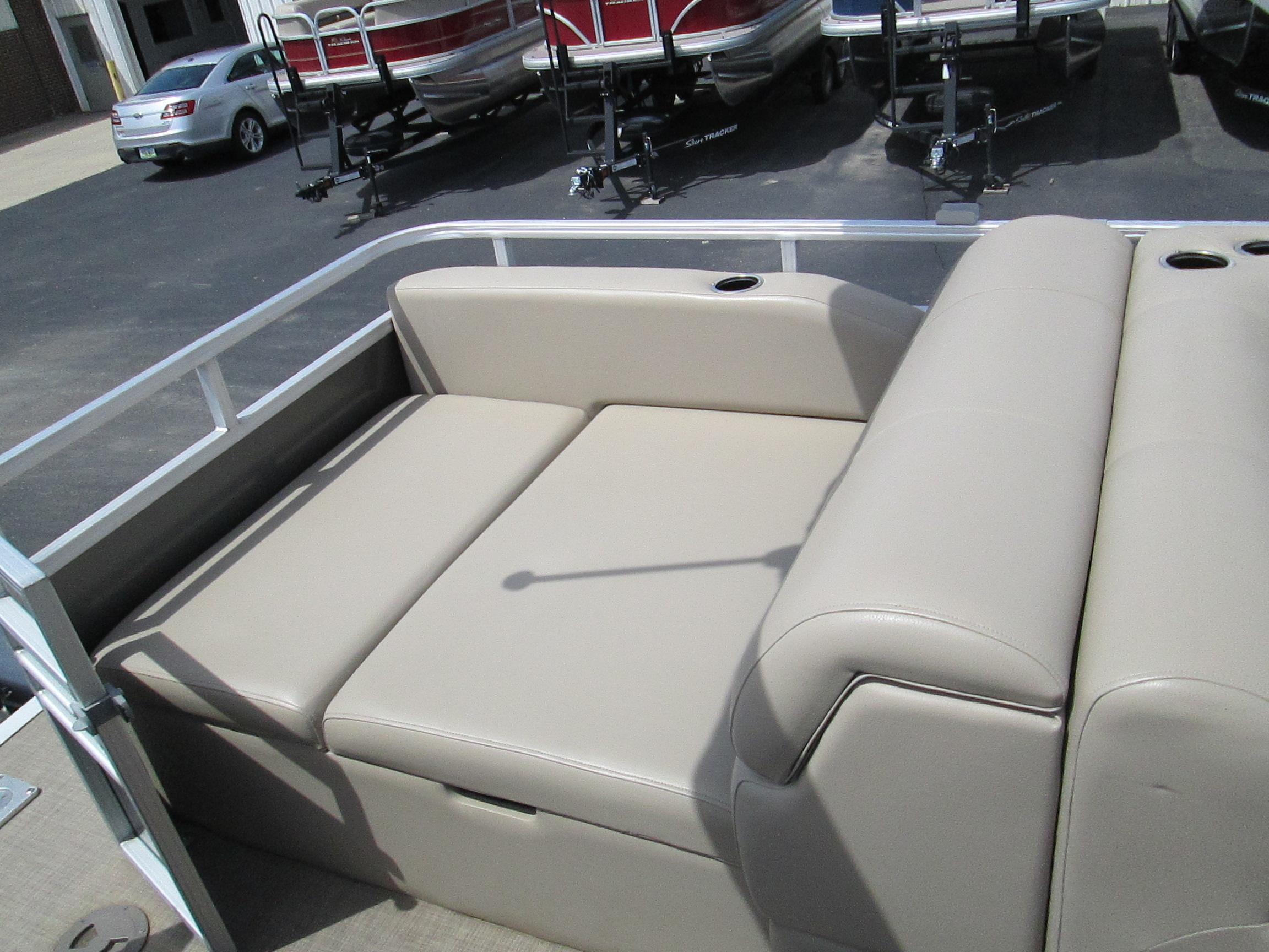 2023 Sun Tracker Party Barge 22 XP3 seating area with beige upholstery and cup holders.