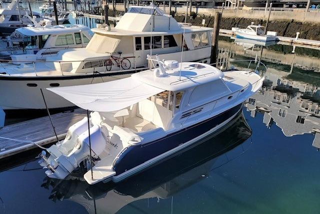 2021 Back Cove 34O boat docked in a marina, featuring a sleek design and sunshade.