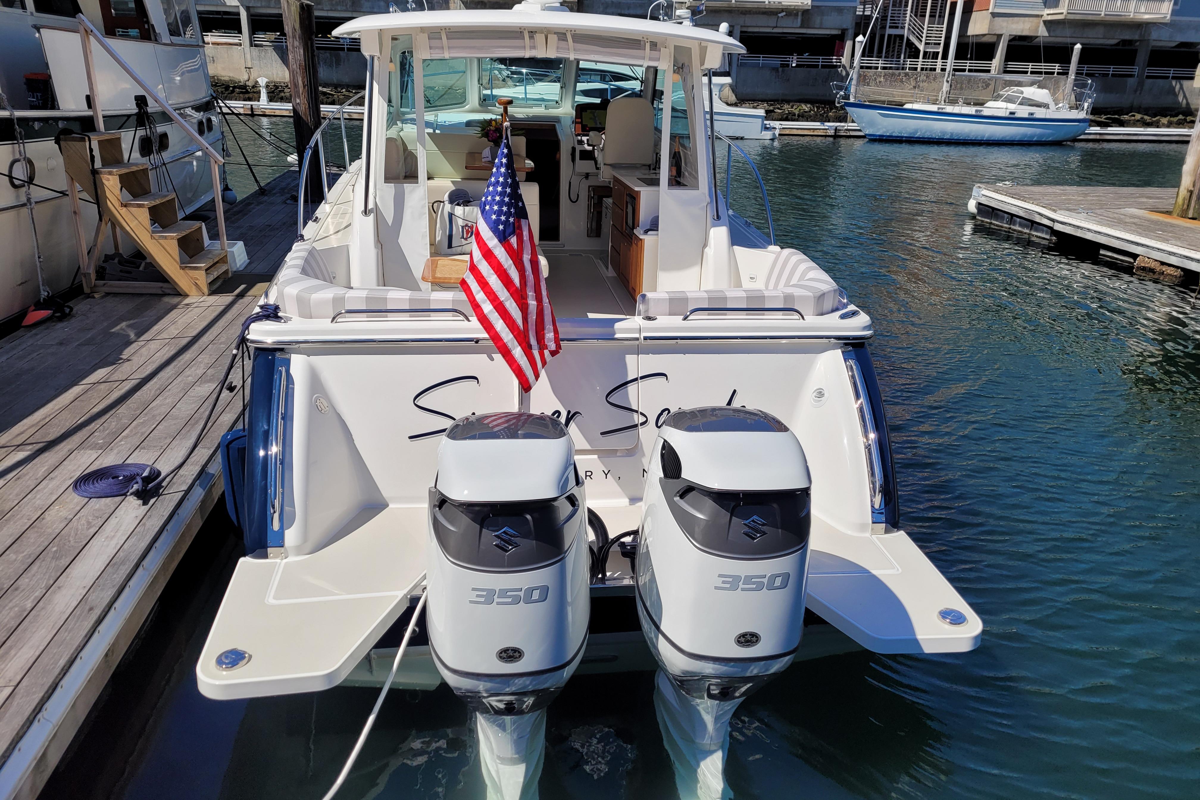 2021 Back Cove 34O boat with dual Suzuki 350 engines, docked with American flag.