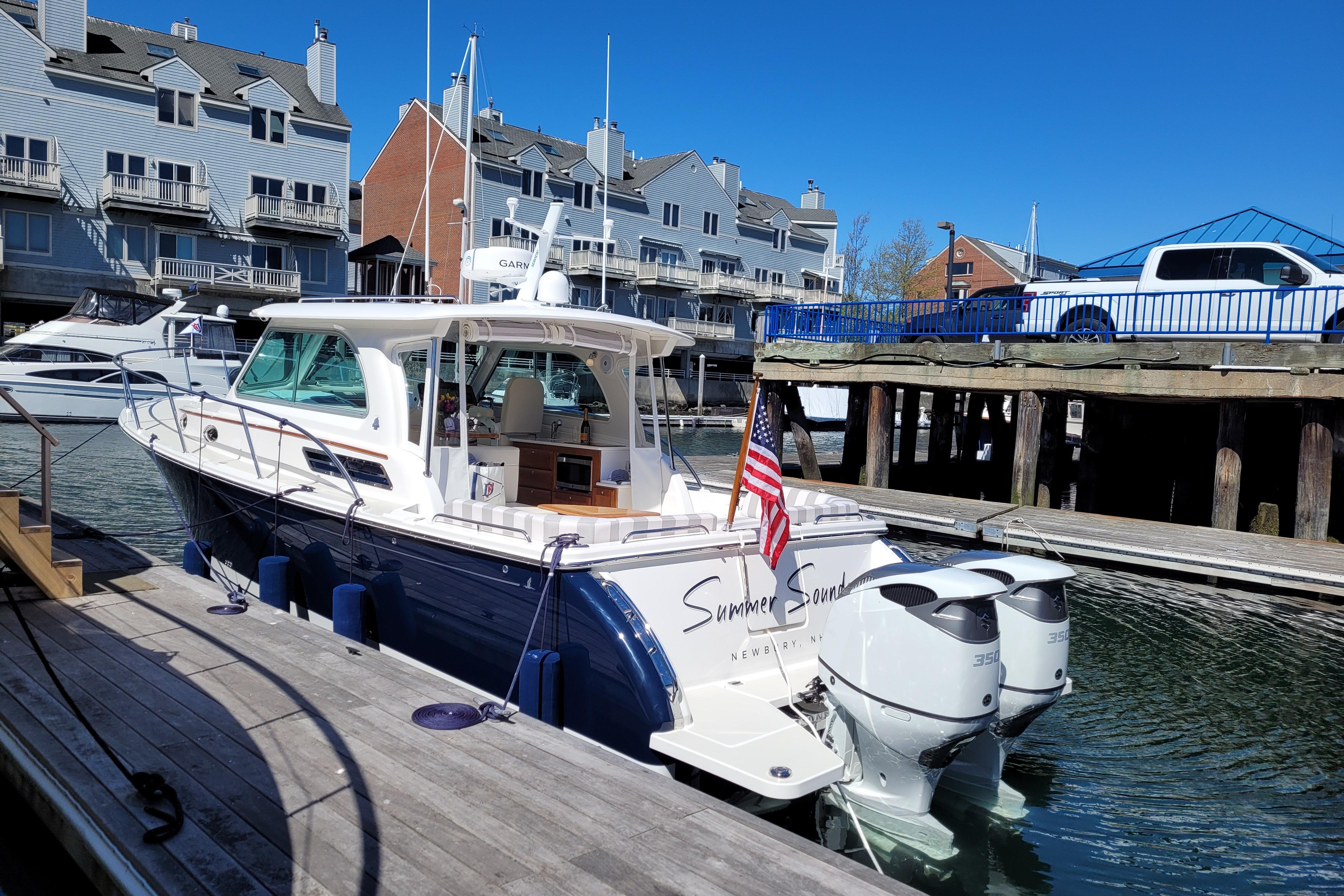 2021 Back Cove 34O boat docked in marina with waterfront buildings.