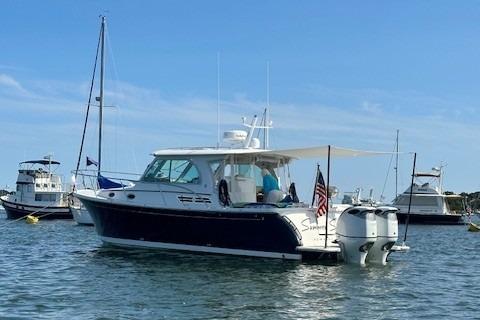 2021 Back Cove 34O boat anchored in a marina with other vessels.