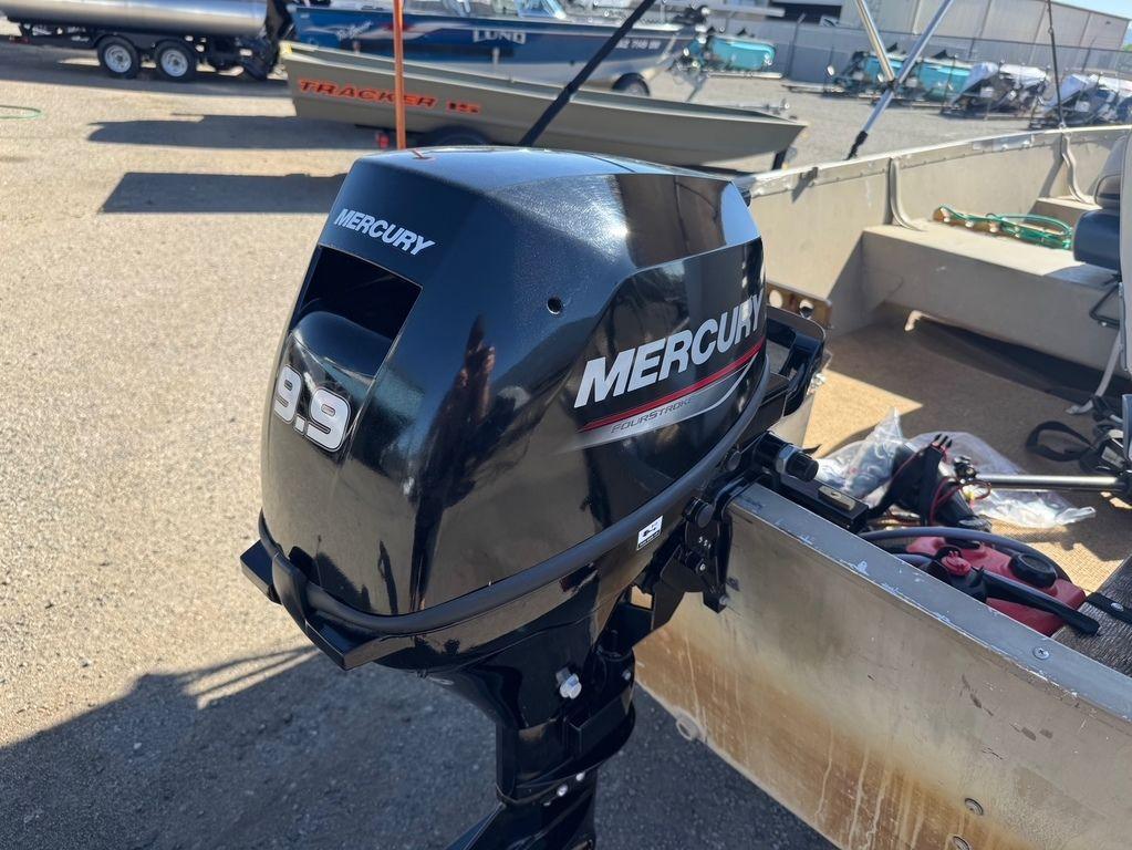 2003 Alumacraft V14 boat with Mercury 9.9 outboard motor in a marina setting.