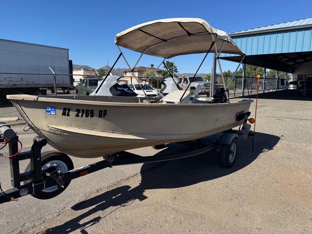2003 Alumacraft V14 boat on trailer with canopy, parked outdoors.