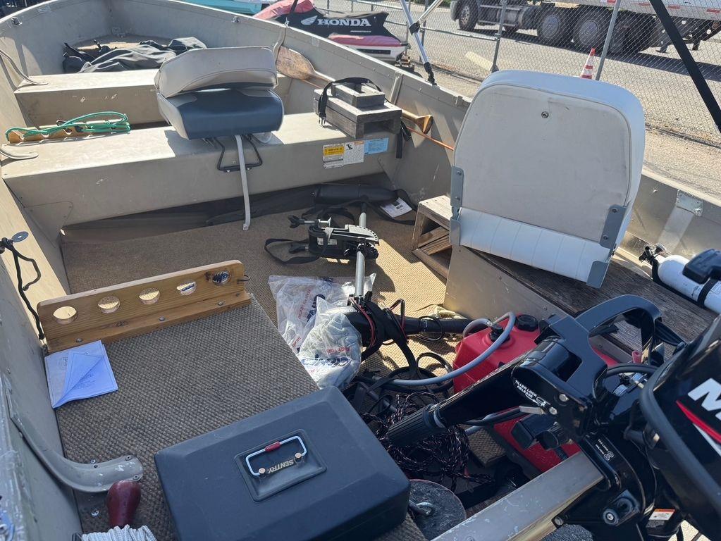 2003 Alumacraft V14 boat interior with seats, equipment, and motor.