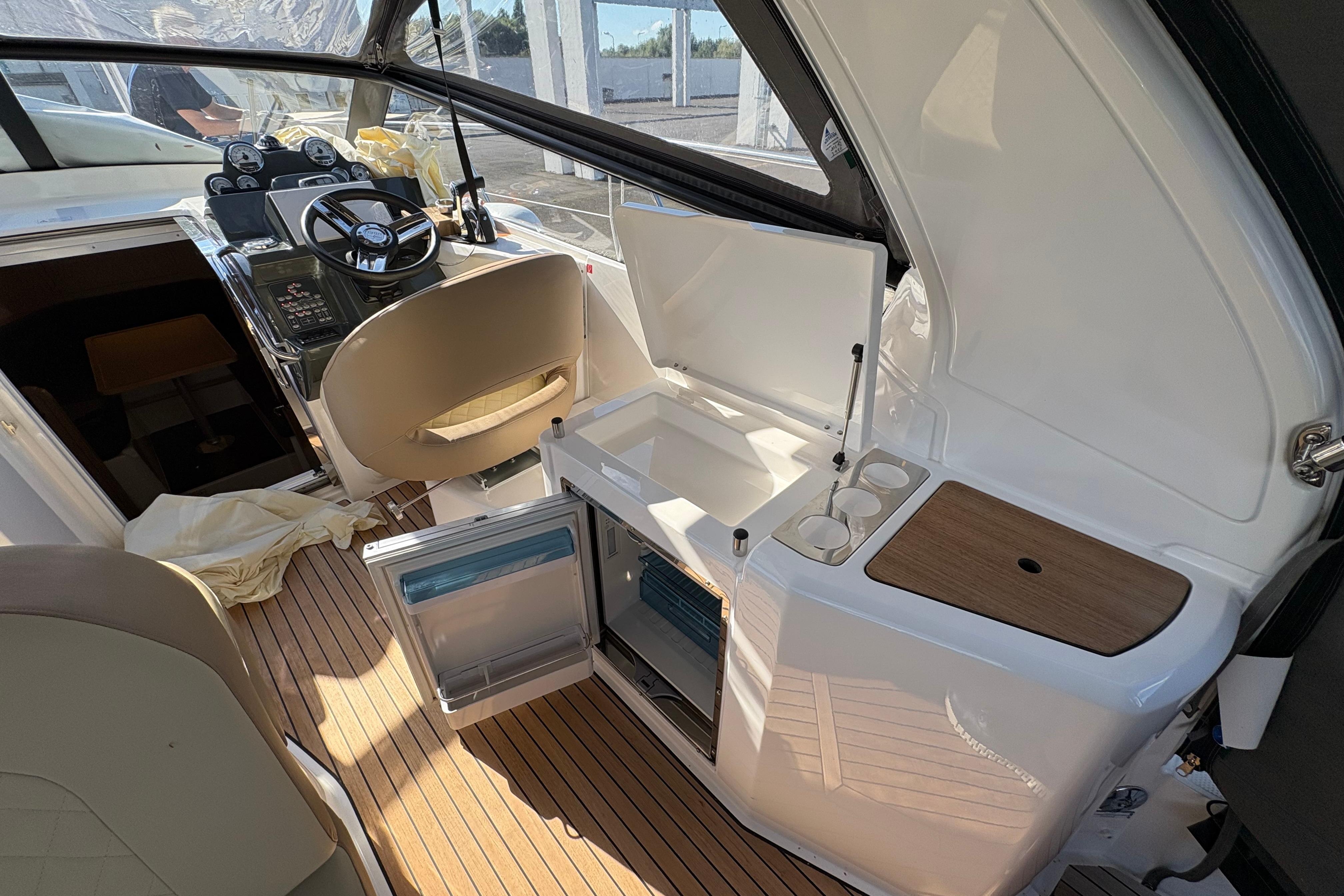 Interior of 2023 Bavaria S30 Open boat with helm, seating, and kitchenette.