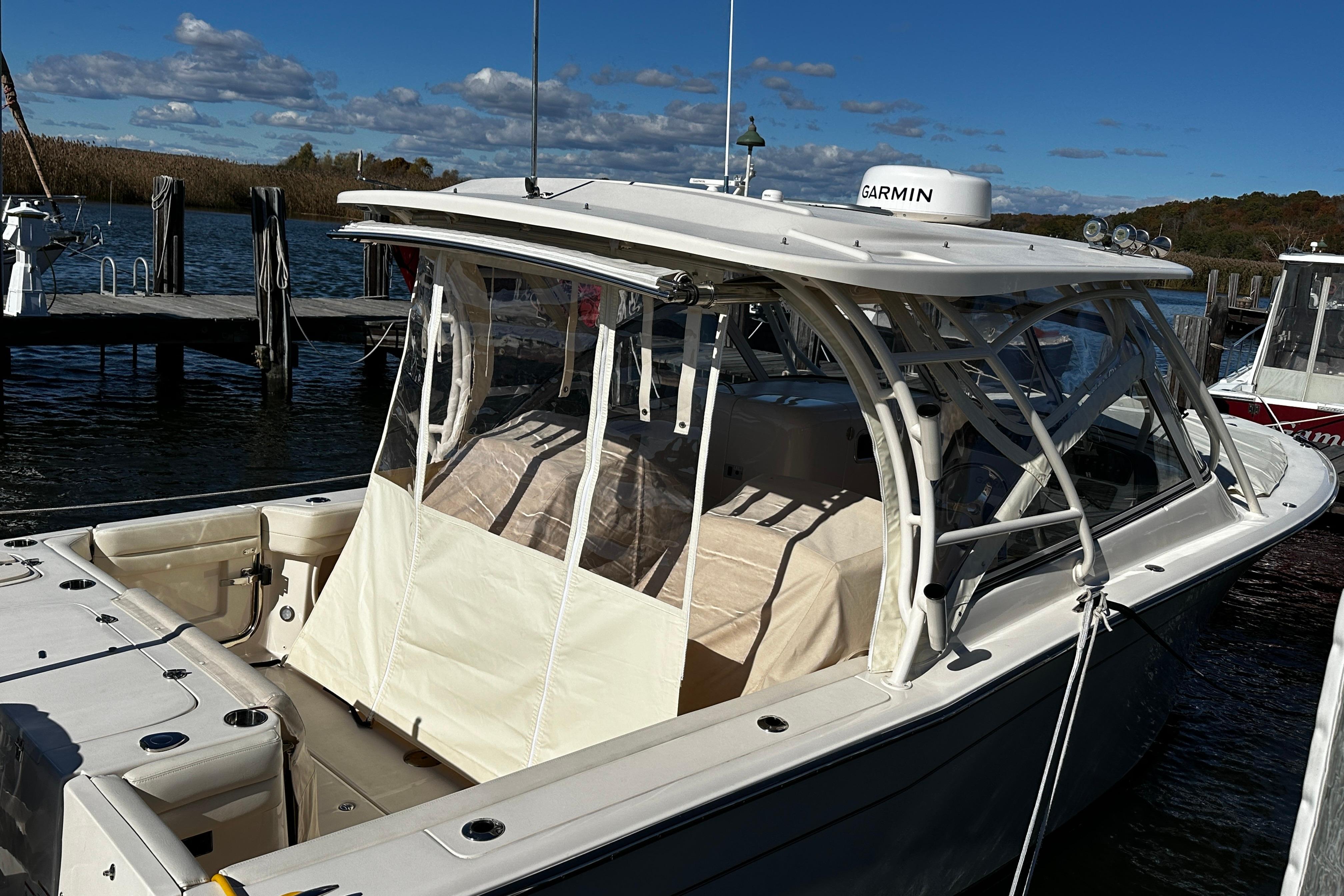 2023 Grady-White Freedom 307 boat docked, featuring a sleek design and Garmin equipment.
