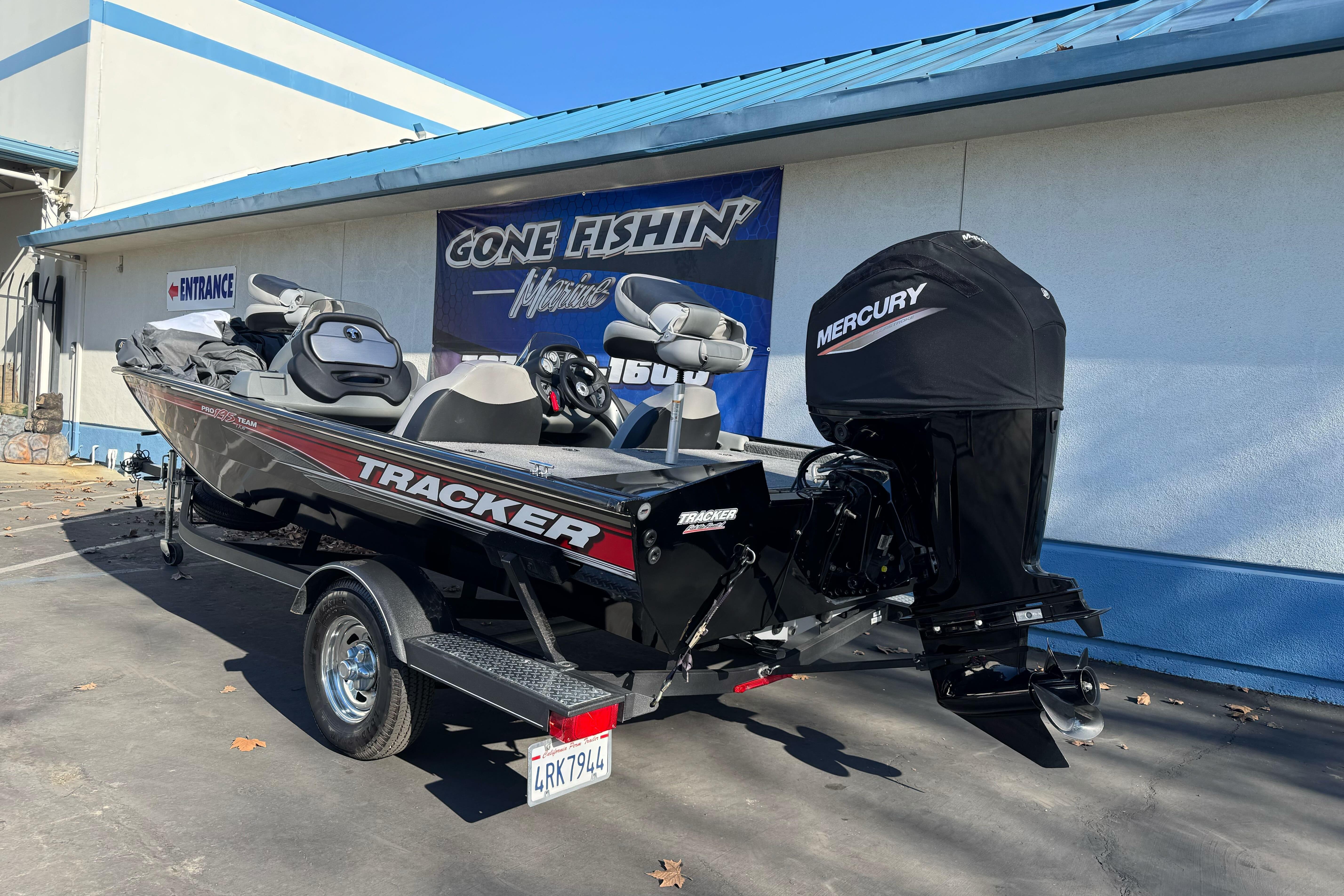 2017 Tracker Pro Team 195 TXW boat with Mercury engine, parked outside a fishing store.