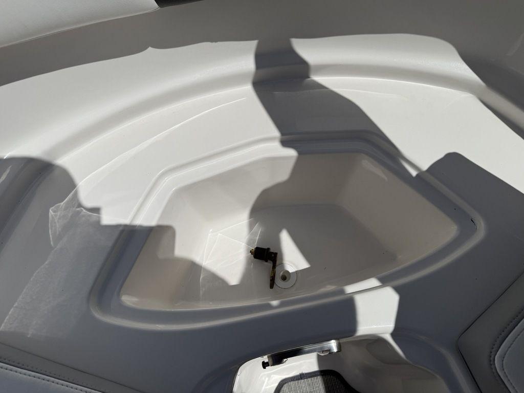 Storage compartment of 2022 Chaparral 23 SSi boat, featuring sleek white interior design.