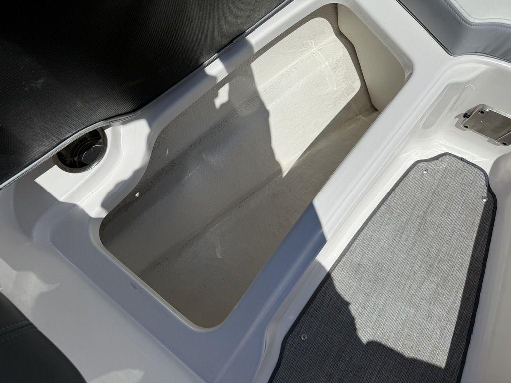 Storage compartment in 2022 Chaparral 23 SSi boat, featuring spacious interior and sleek design.