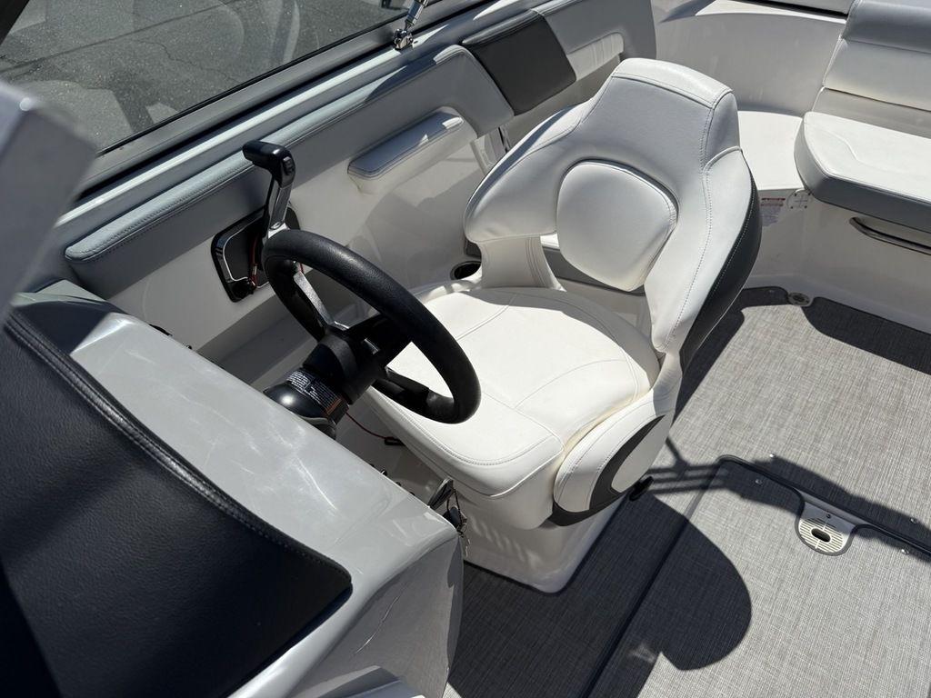2022 Chaparral 23 SSi boat cockpit with white captain's chair and steering wheel.