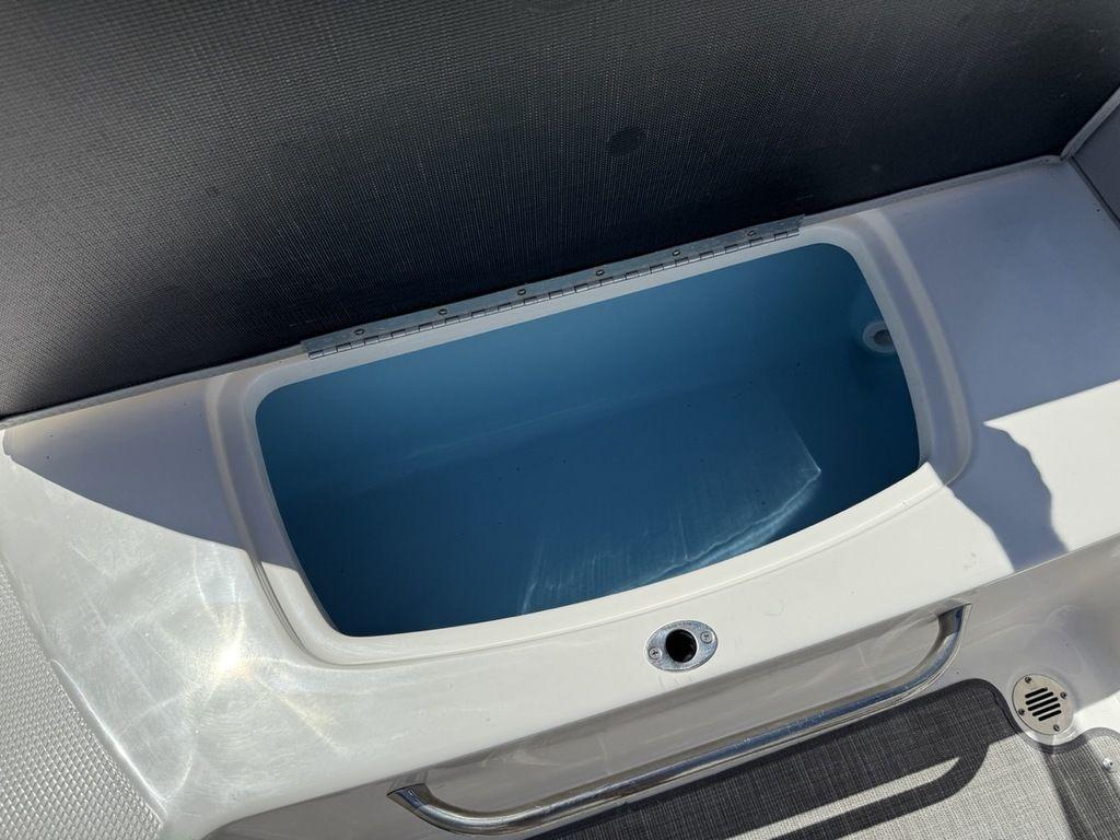 2022 Chaparral 23 SSi boat storage compartment, open and empty, with a blue interior.