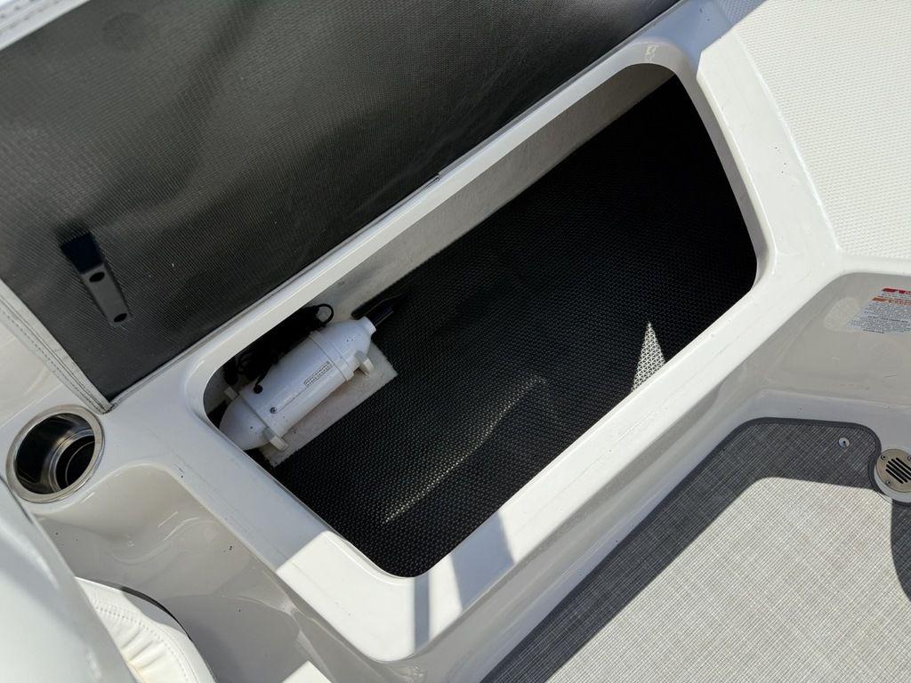 Storage compartment in 2022 Chaparral 23 SSi boat, featuring a clean, organized interior.