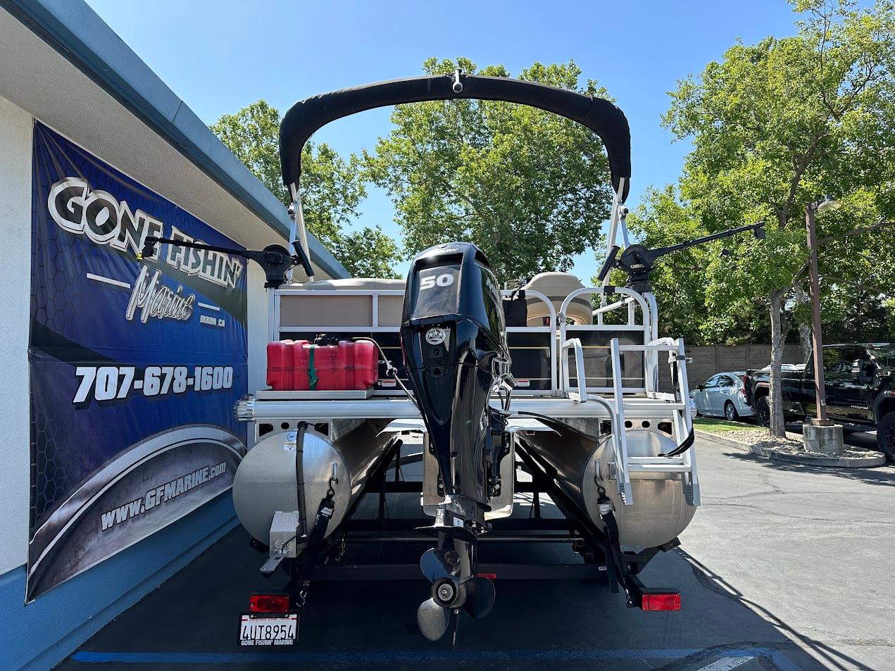 2022 Sun Tracker Bass Buggy 16 XL Select pontoon boat with outboard motor, parked outdoors.