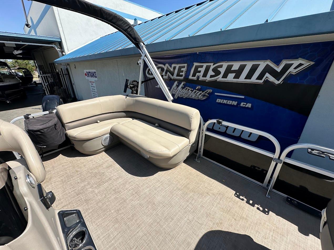 2022 Sun Tracker Bass Buggy 16 XL Select pontoon boat with beige seating and blue accents.