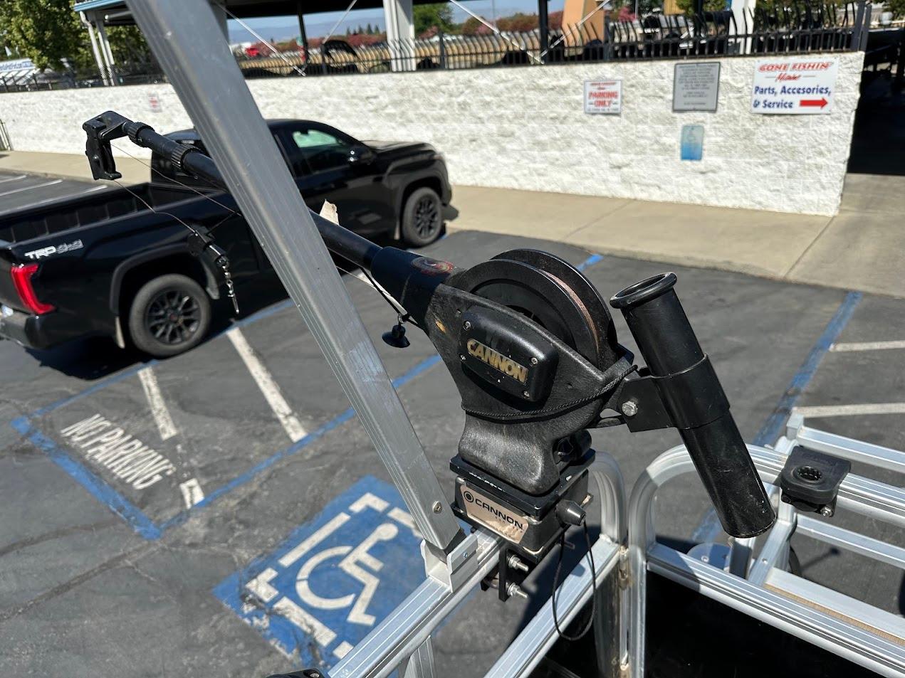 2022 Sun Tracker Bass Buggy 16 XL Select with fishing rod holder in a parking lot.