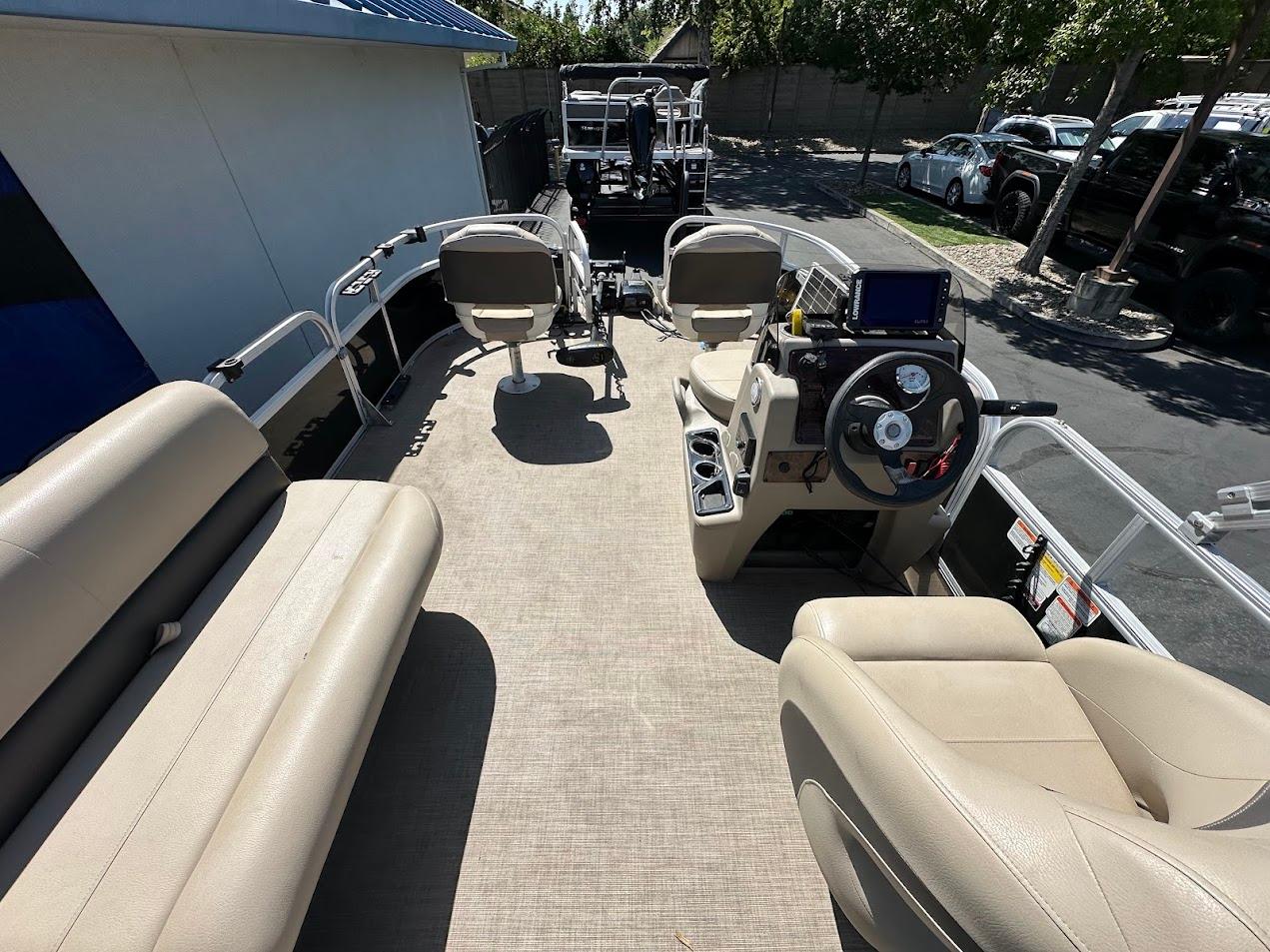 2022 Sun Tracker Bass Buggy 16 XL Select pontoon boat interior with beige seating and steering console.