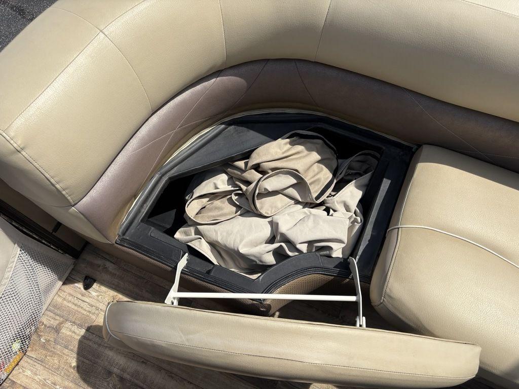 Open storage compartment in 2017 Crest Classic 250L boat seat with beige upholstery.