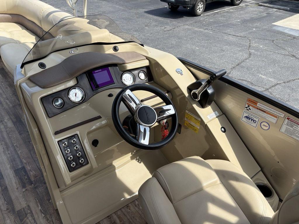 Steering console of 2017 Crest Classic 250L USD CP3 boat with beige seating and controls.