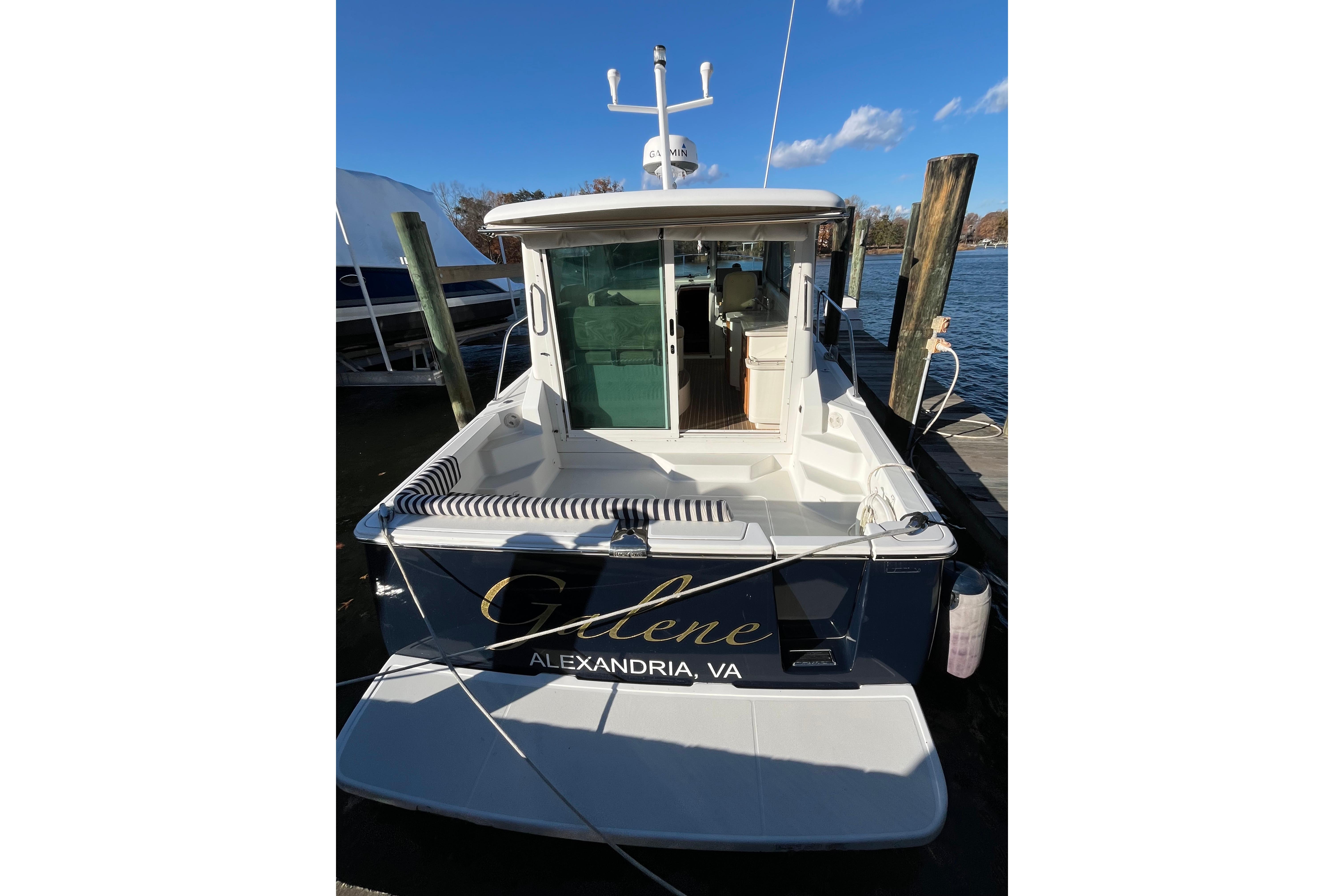 2010 Back Cove 33 Express Hardtop docked, rear view with open cabin door.