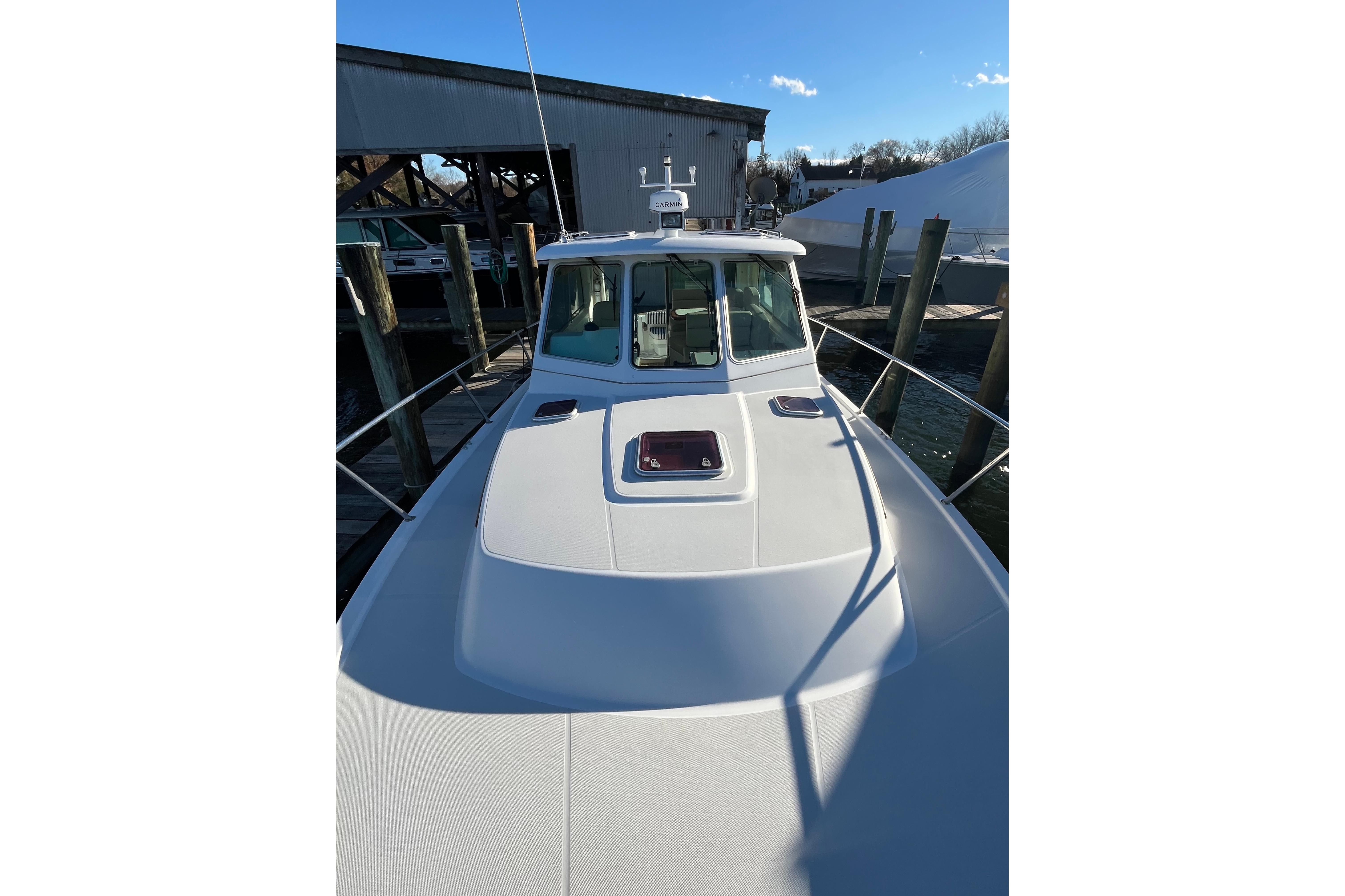 2010 Back Cove 33 Express Hardtop boat docked at marina under clear blue sky.
