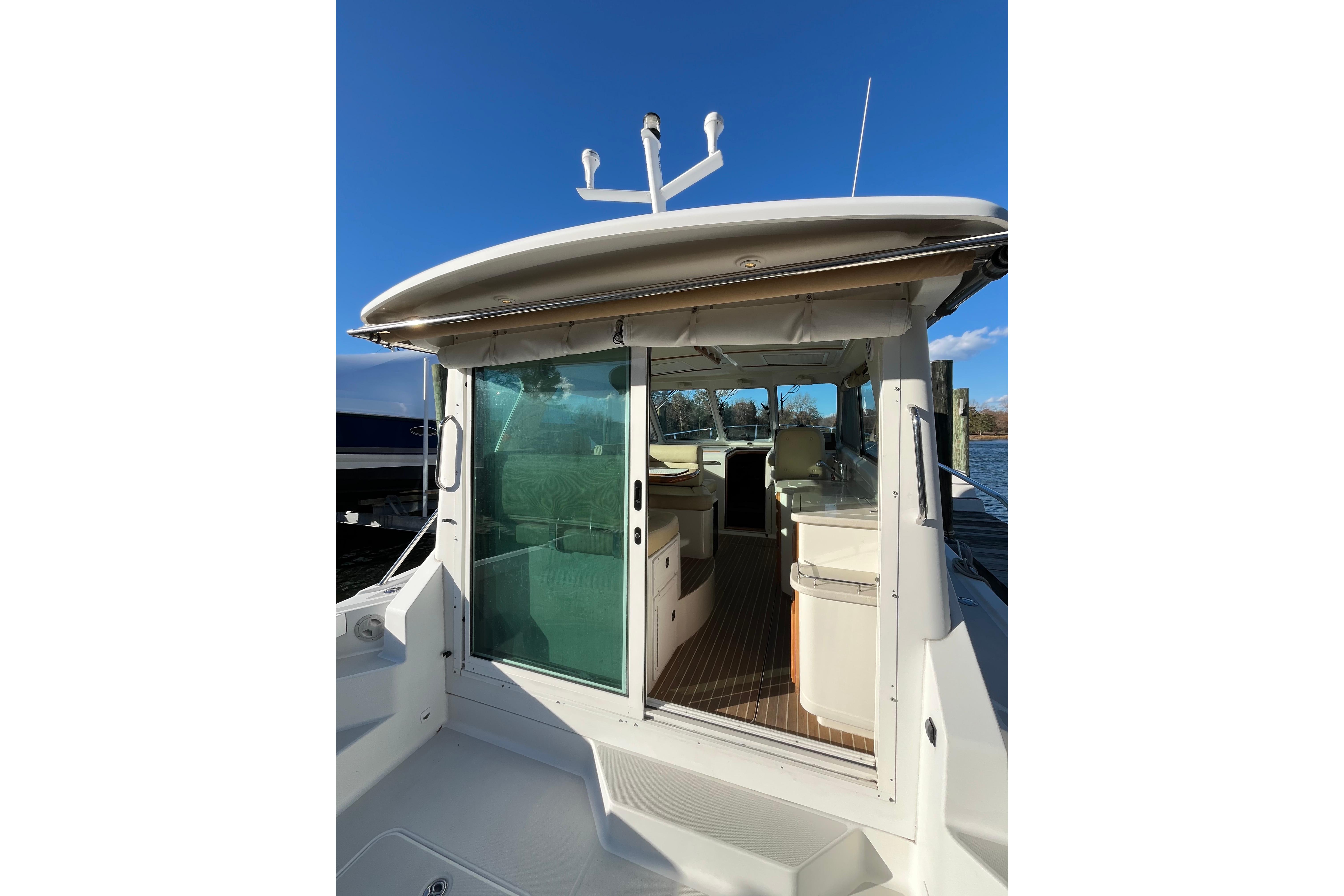 2010 Back Cove 33 Express Hardtop boat with open cabin and clear blue sky.