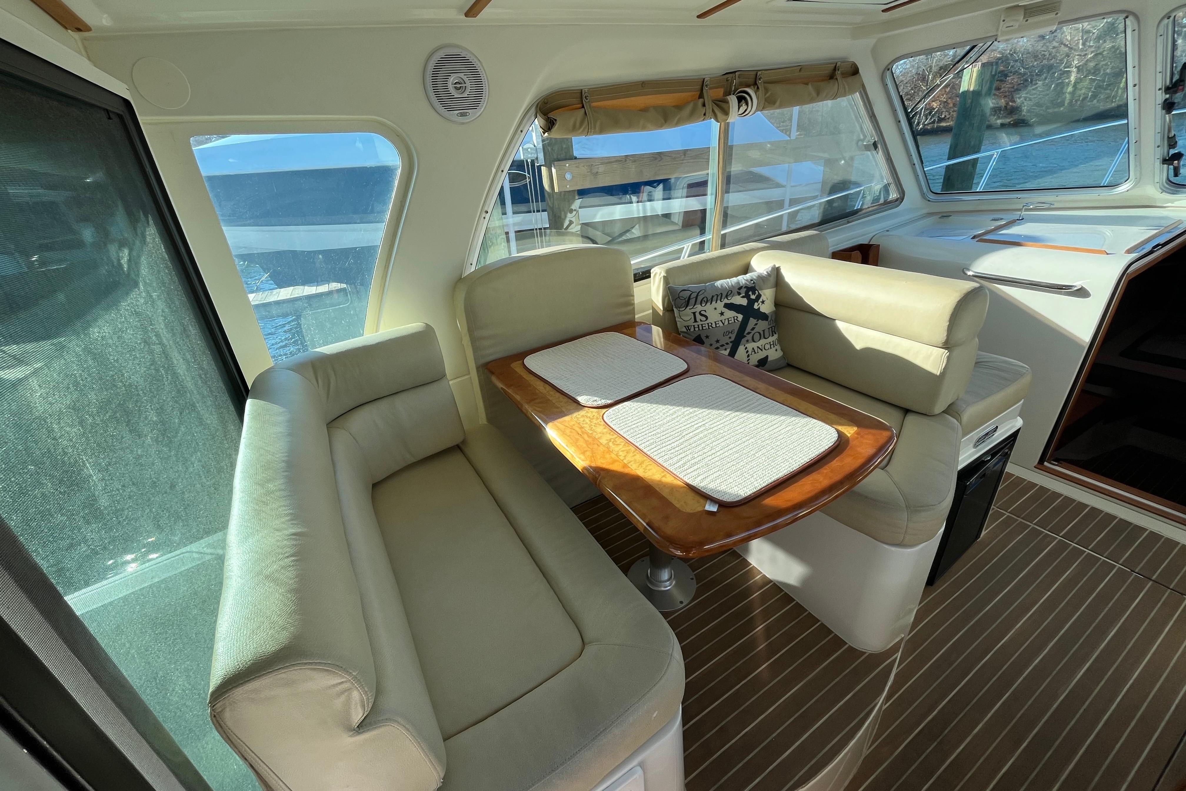 2010 Back Cove 33 Express Hardtop interior with beige seating and wooden table.