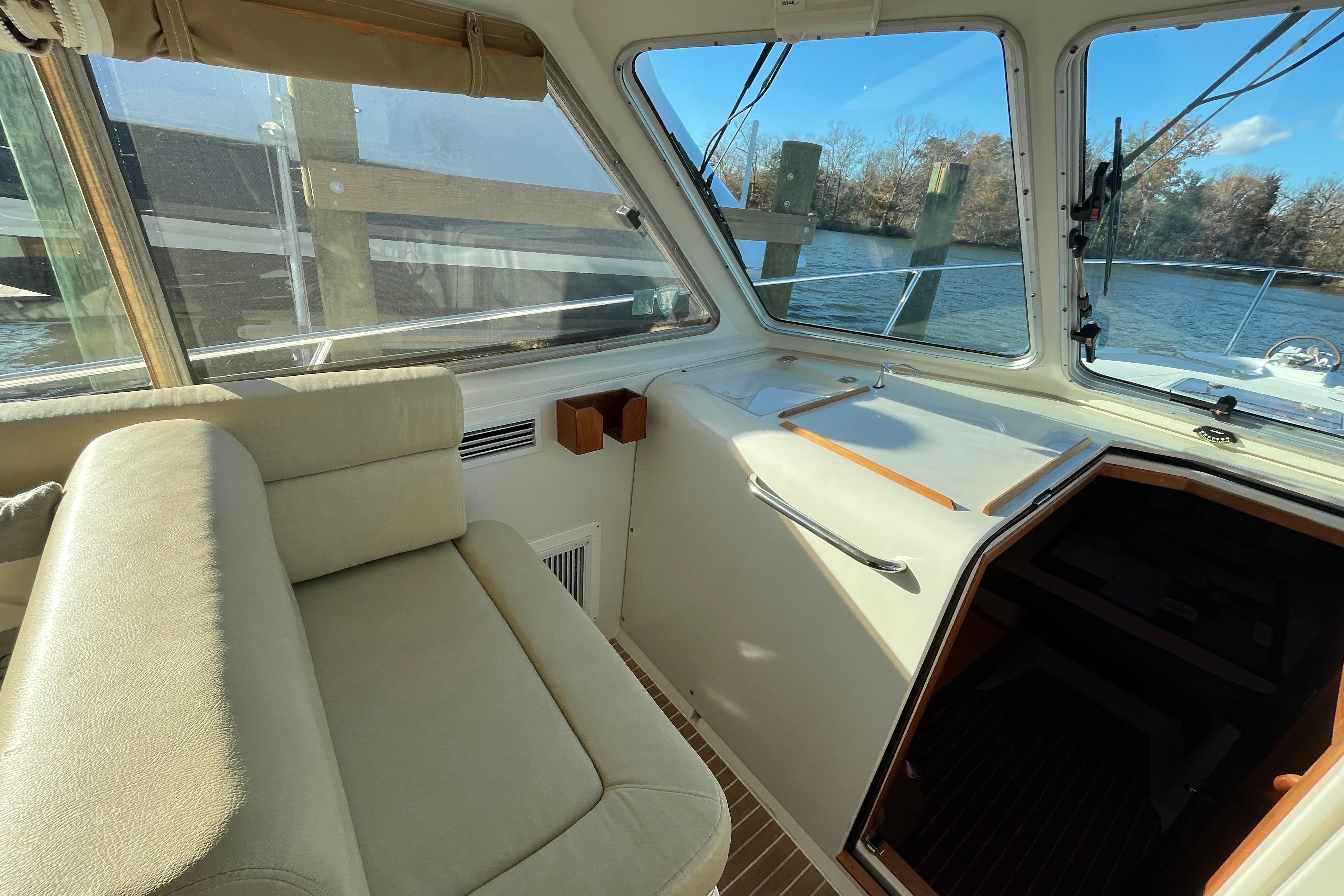 Interior of 2010 Back Cove 33 Express Hardtop boat with seating and windows overlooking water.
