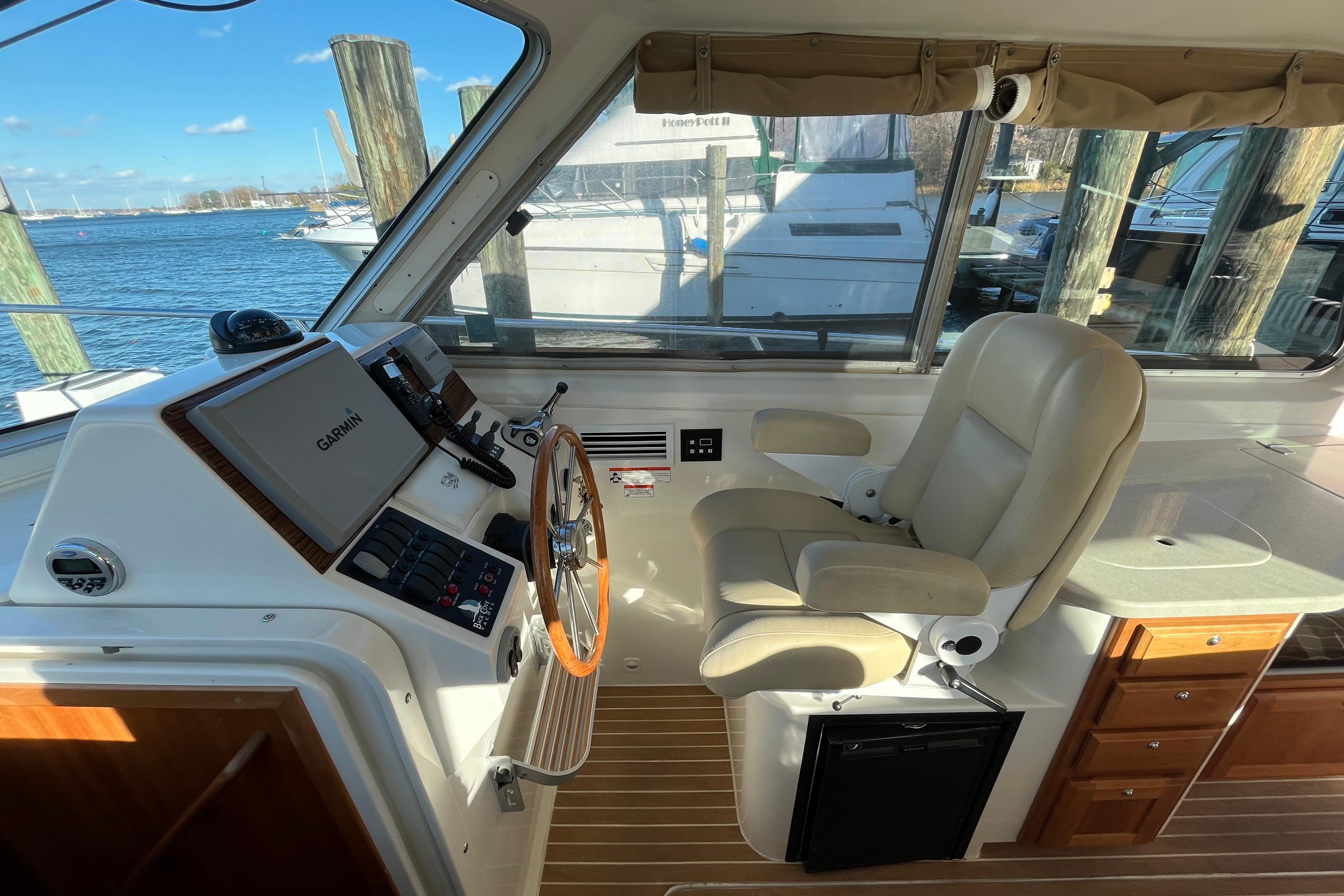 2010 Back Cove 33 Express Hardtop helm with Garmin navigation, leather seat, and wood accents.