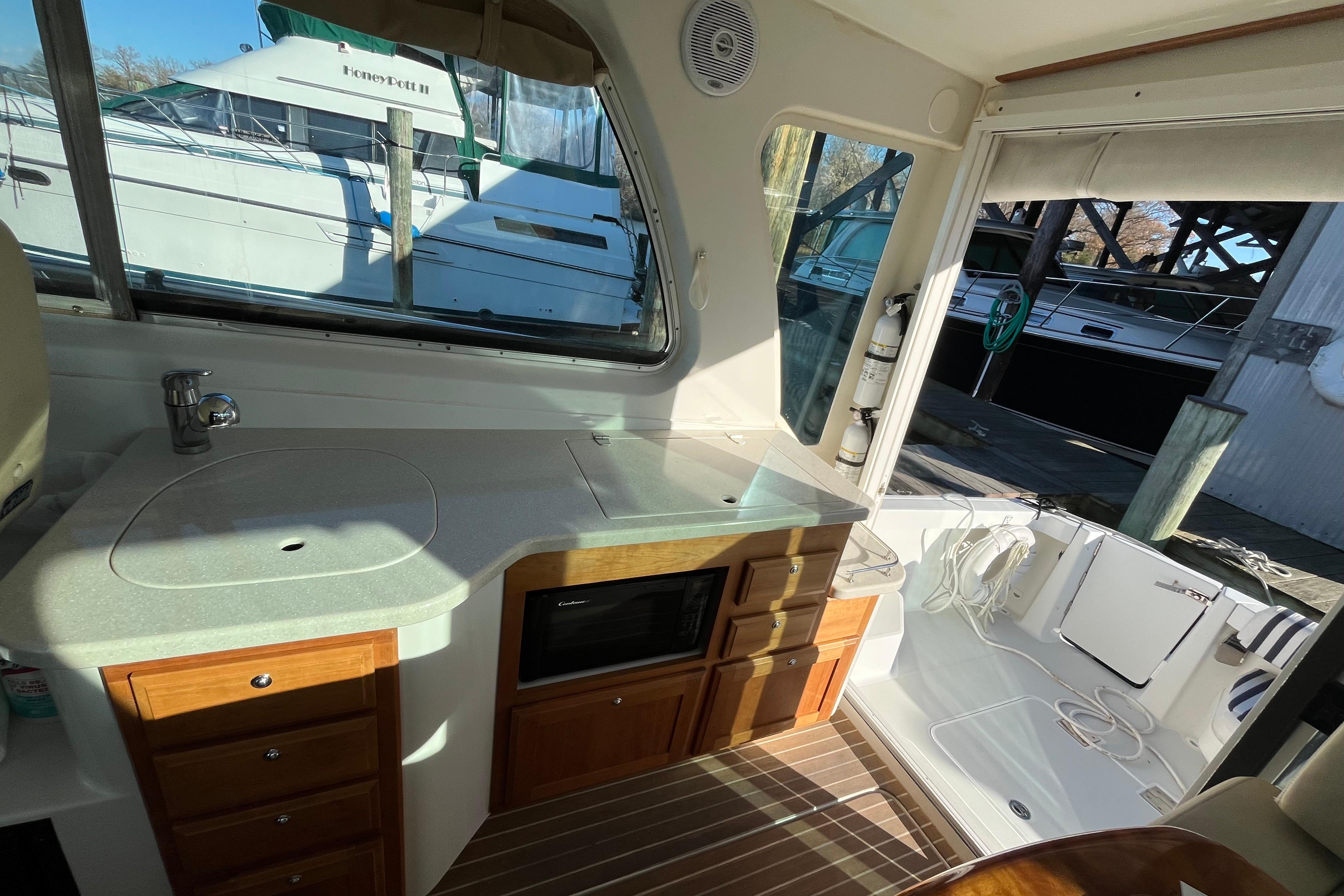 2010 Back Cove 33 Express Hardtop interior with kitchenette and dock view.