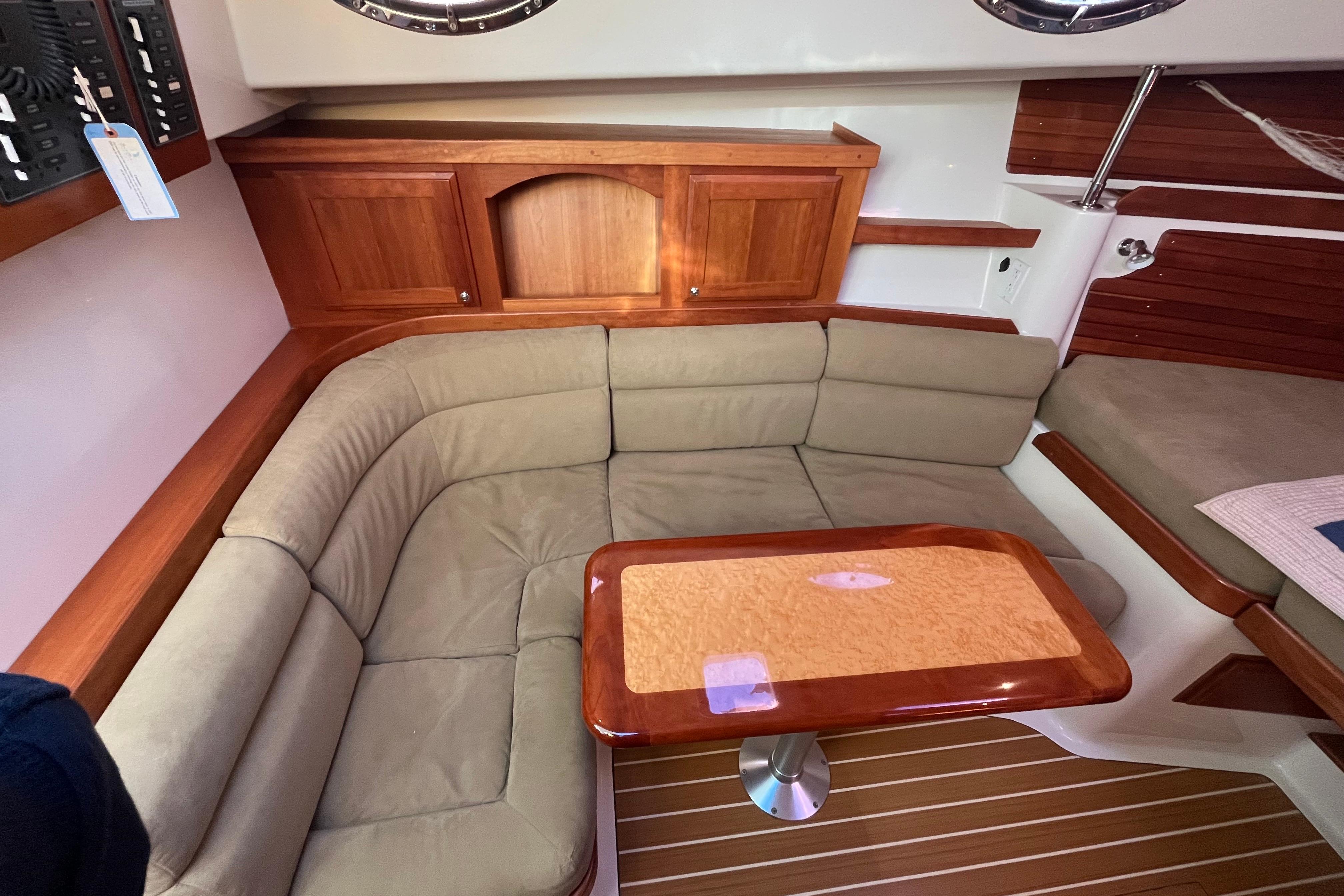 2010 Back Cove 33 Express Hardtop interior with beige seating and wooden table.